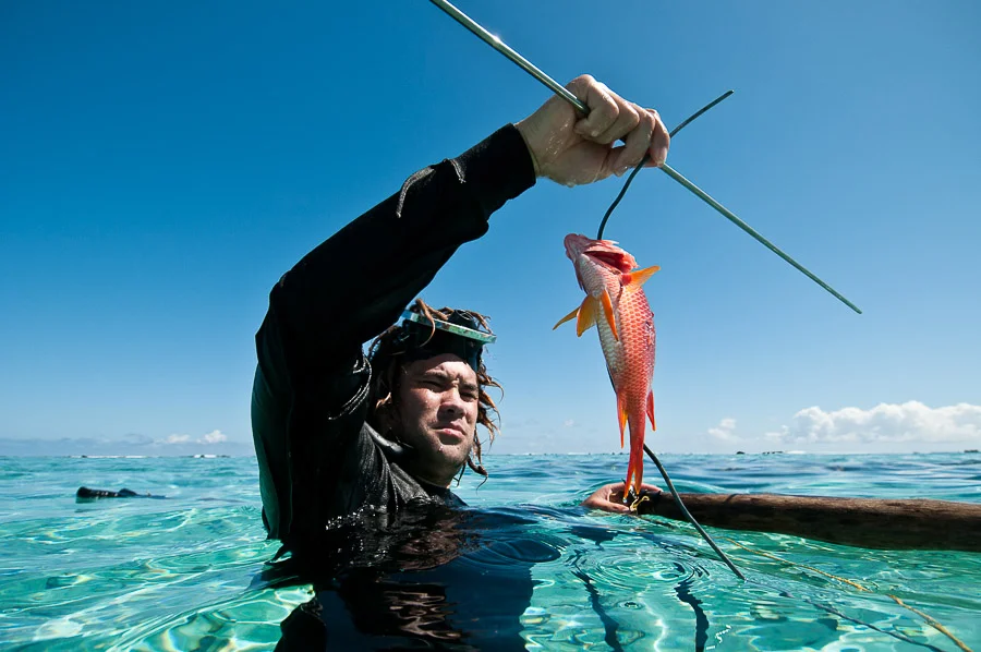 Spear fisherman with a freshly caught fish, Aitutaki, Cook Islands.