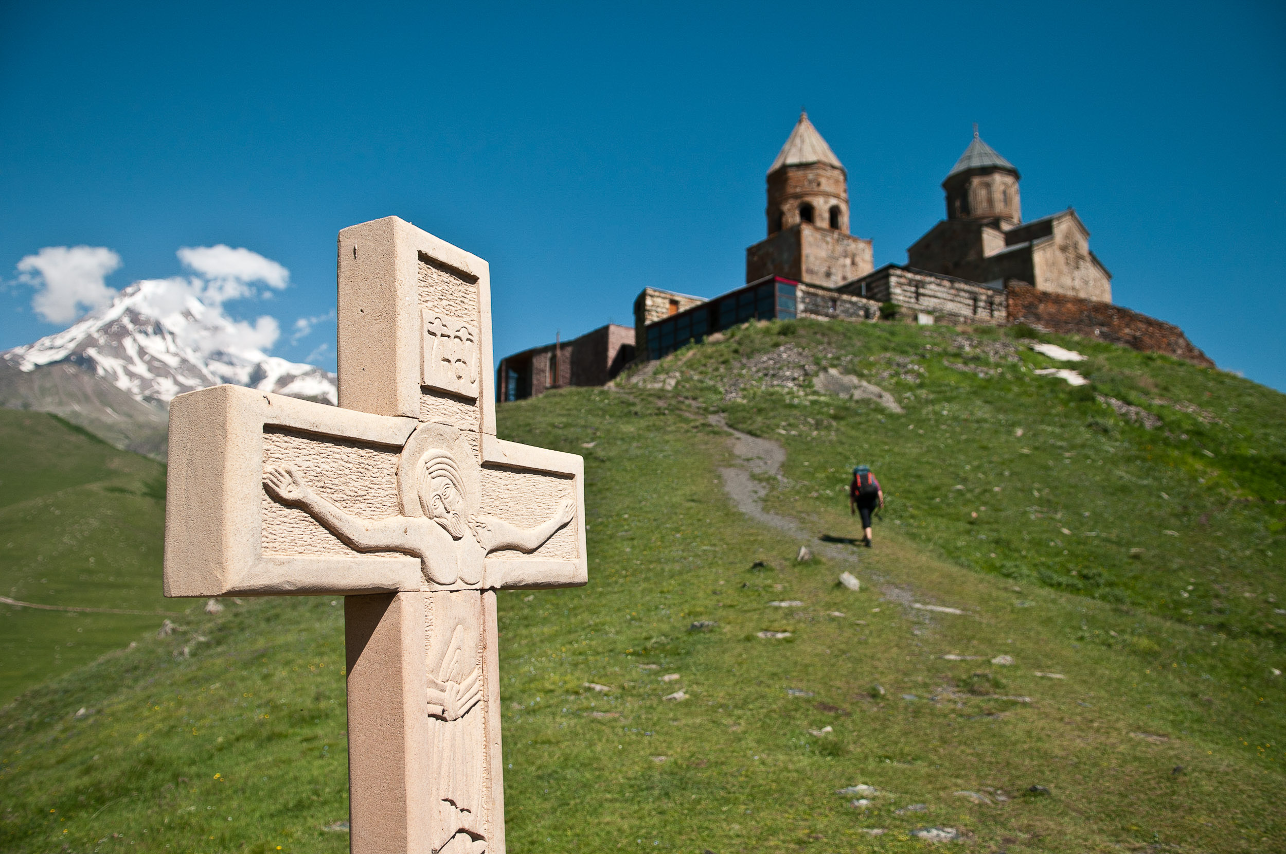 Cross and church above Kazbegi village, Georgia