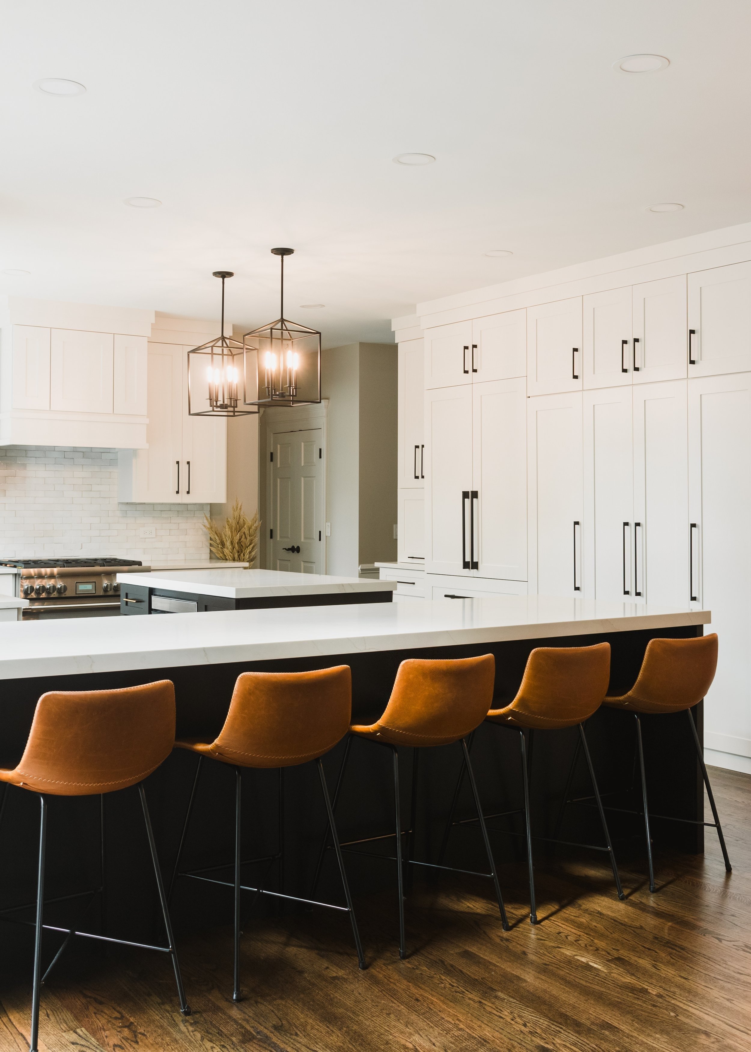 white-kitchen-island-with-pendant-lights-and-brown-bar-stools.jpg.jpg