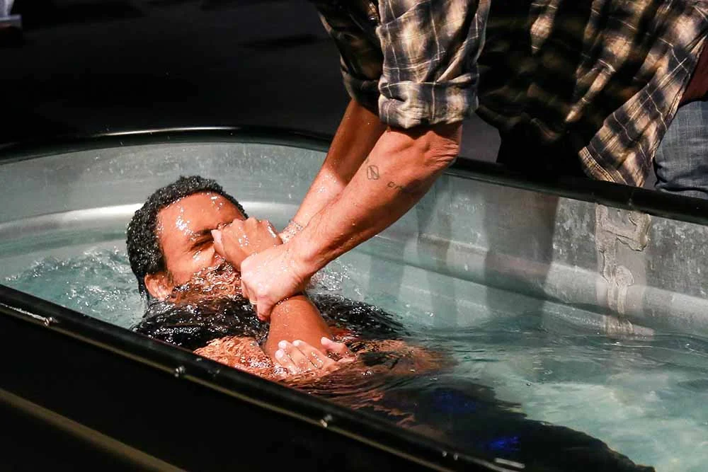 Man is lifted out of the waters of baptism during a Pulse service