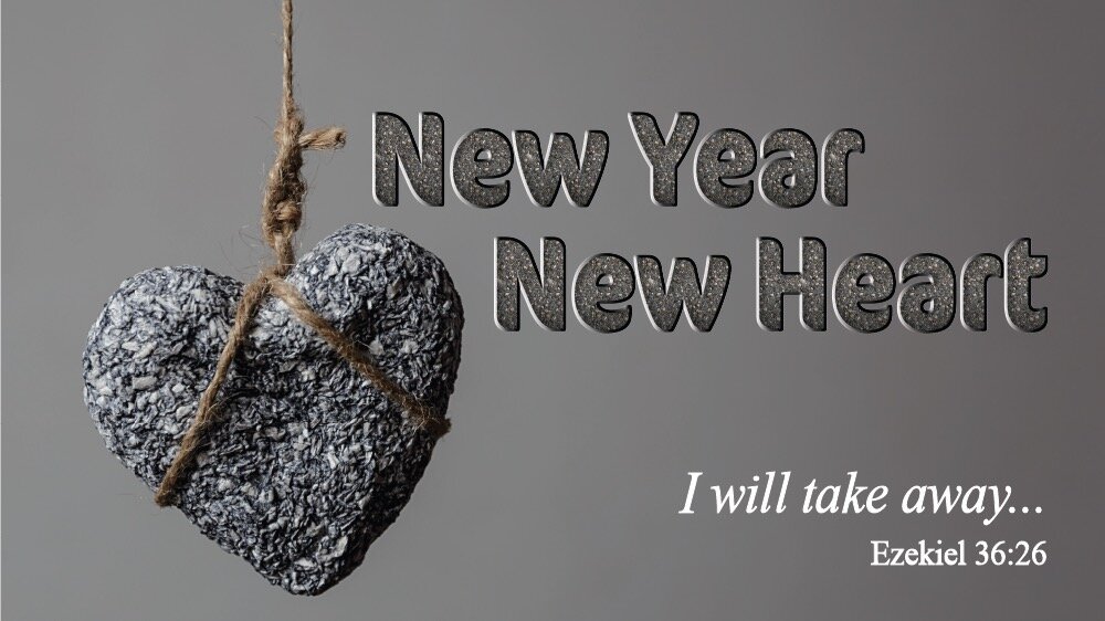 A Stone heart hangs from a thin rope. 'New Year New Heart' is written next to it