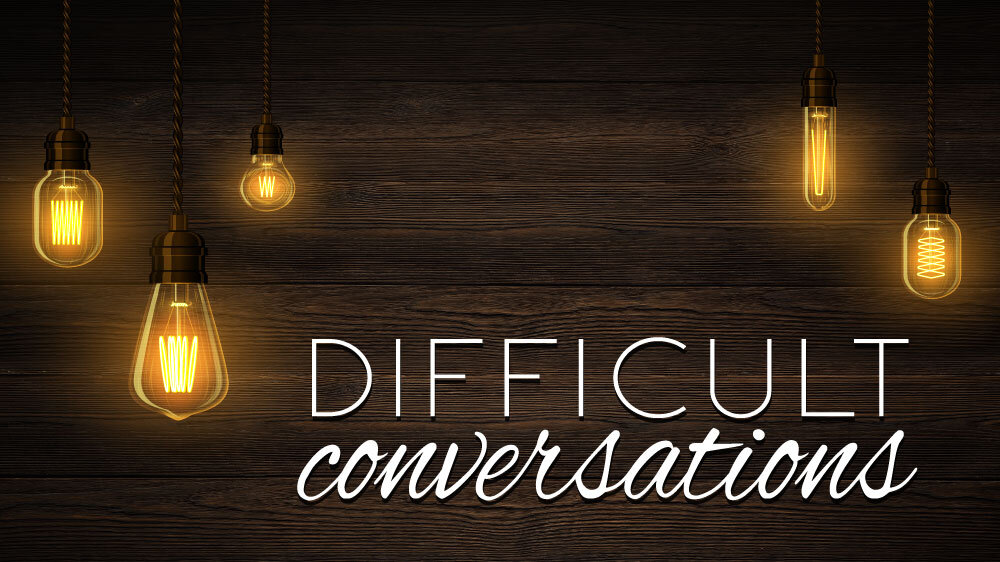 Edison lightbulbs hand against a wooden wall. "Difficult Conversations" is superimposed