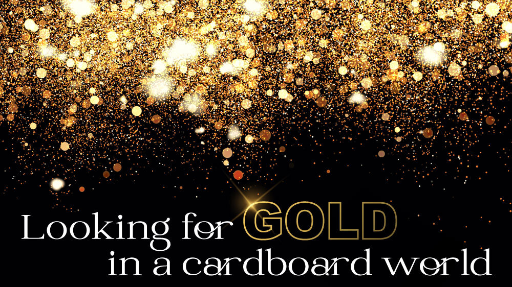 Gold Glitter glistens against a dark background. "Looking for gold in a cardboard world" is written across the bottom.