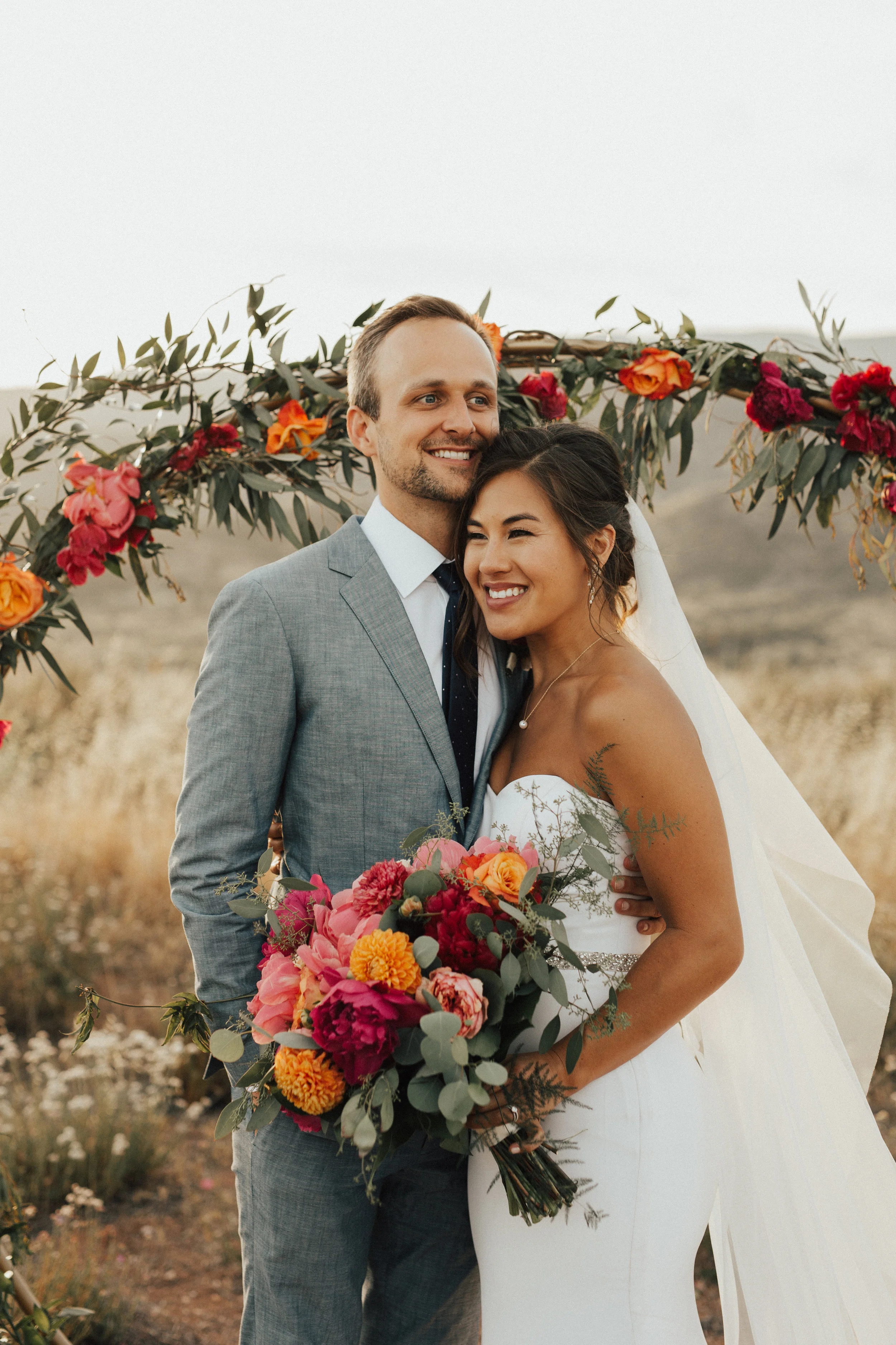 bride and groom, vibrant flower arrangement || Orange Blossom Special Events