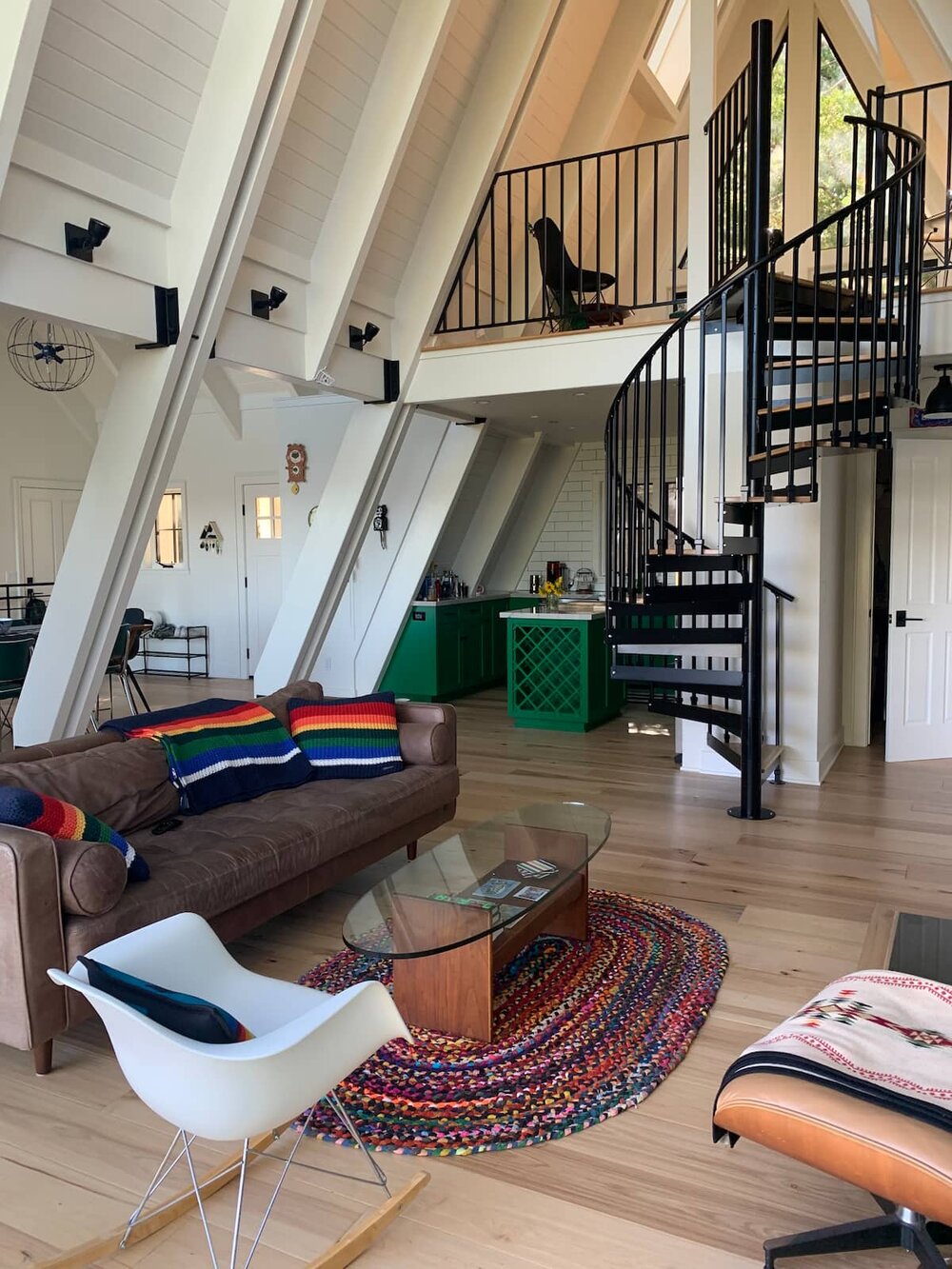 one of the A-Frame Cabins in airbnb with glass windows  and leather couch 