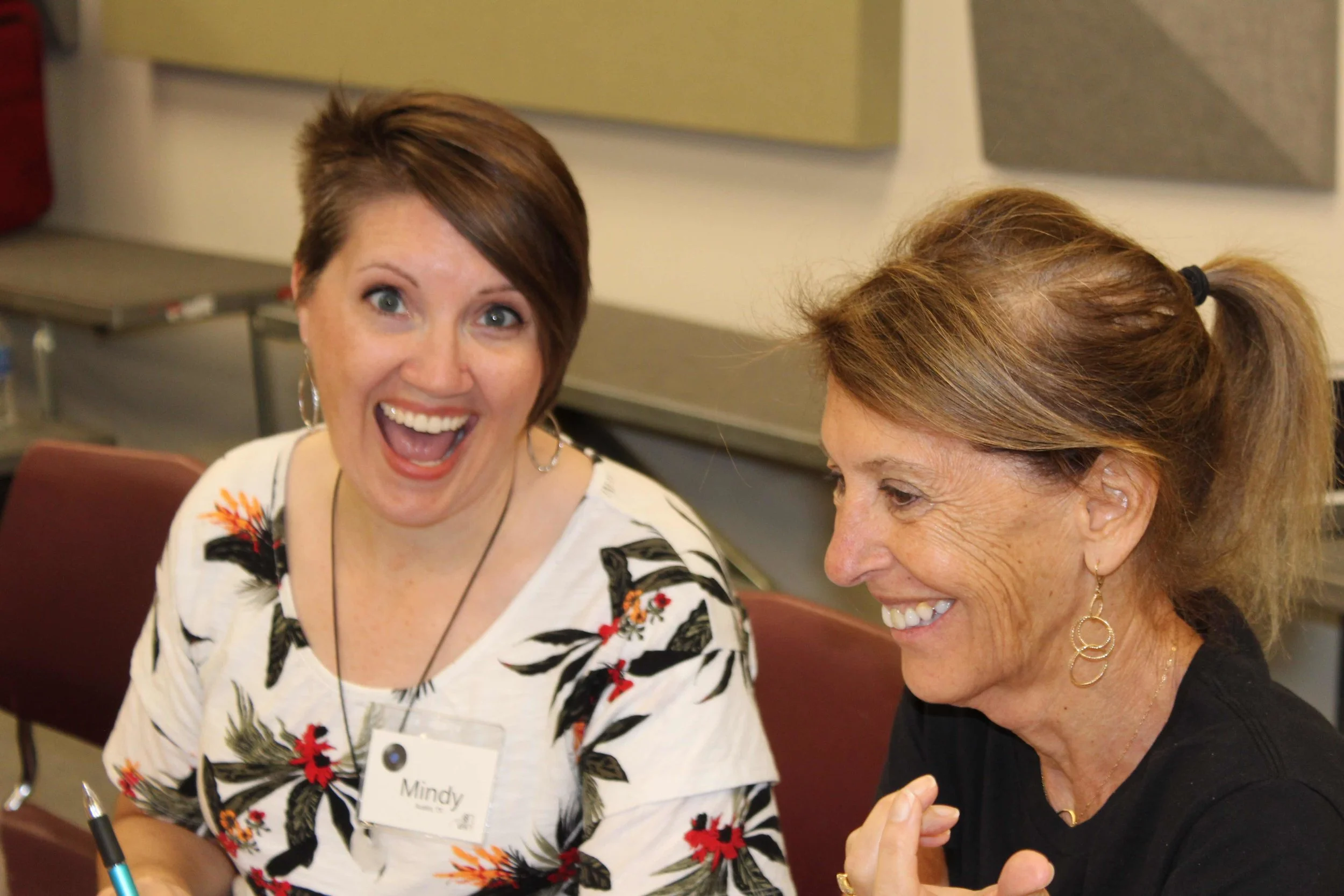 Mindy smiling for the camera sitting next to Andrea West, Ms 88PK graphics guru