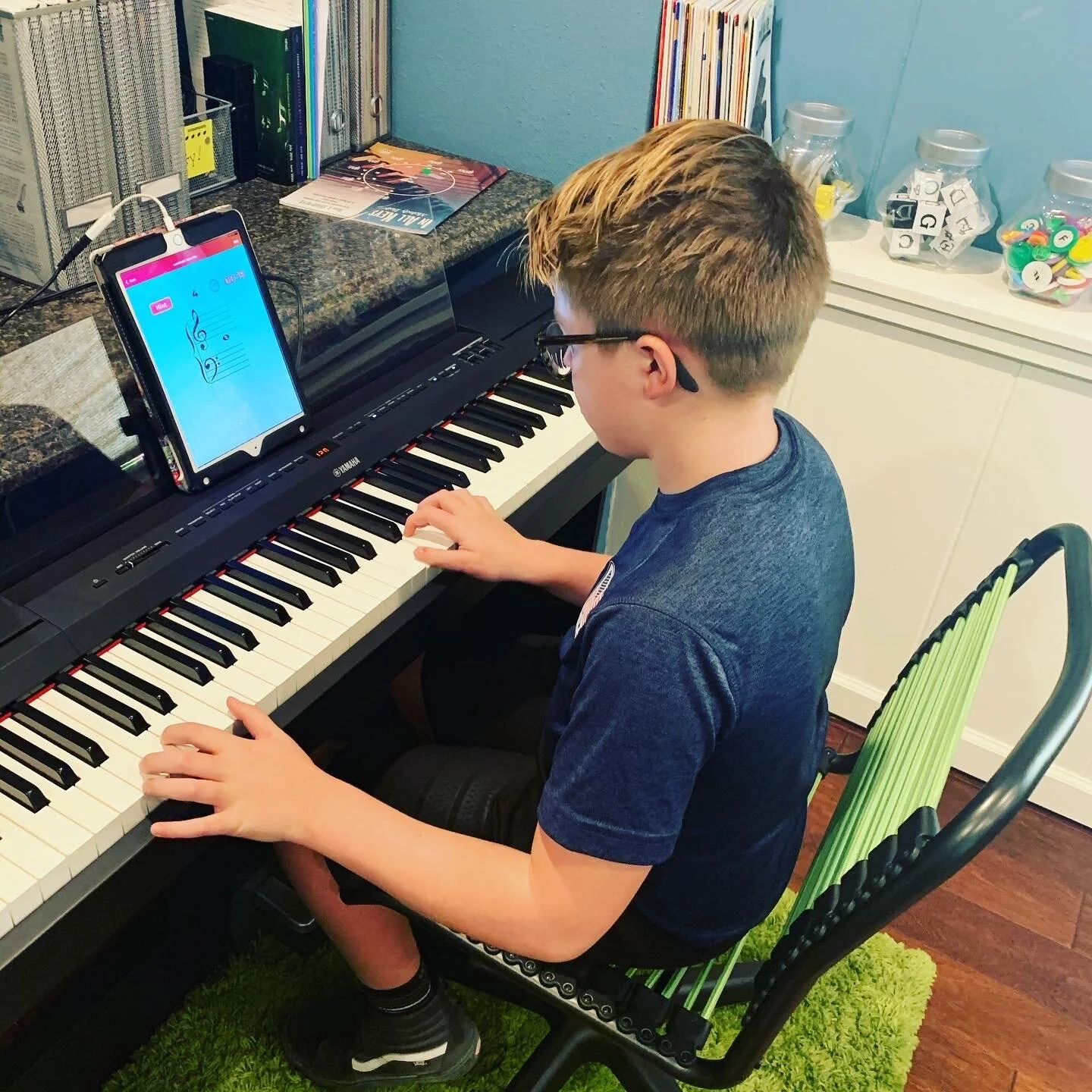 Piano student using an iPad app at keyboard in Centennial