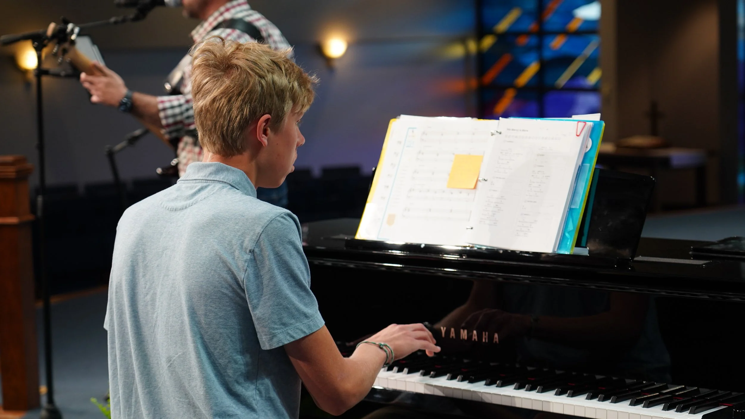 Piano student performing with a live band during a creative spring recital.