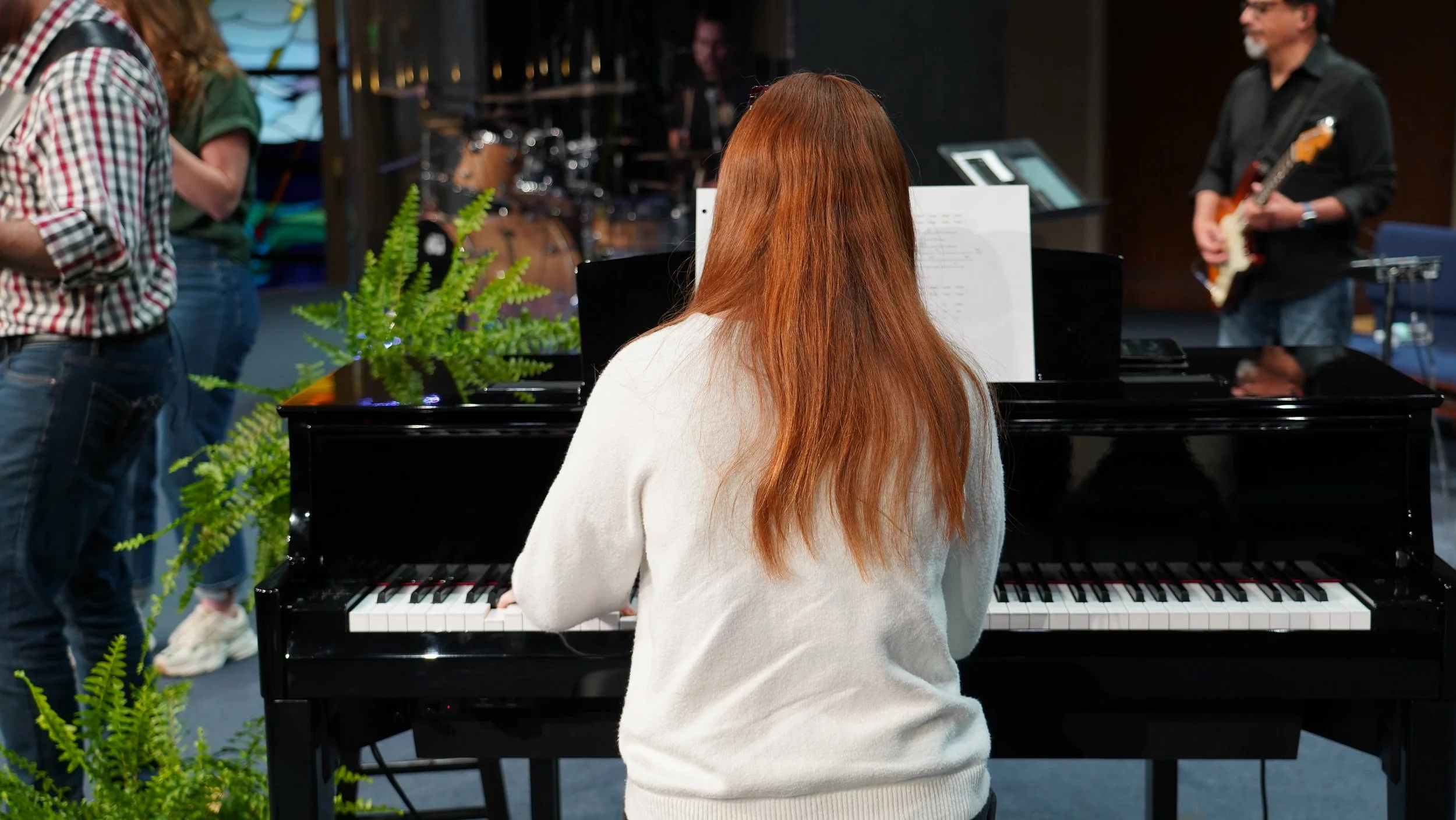 Collaborative music-making during a live band piano recital.