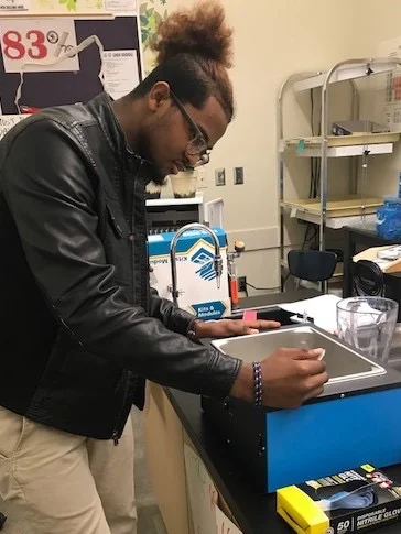 DDHS student uses the water bath to transfer the pGlo jellyfish gene into bacteria plasmid (DNA).