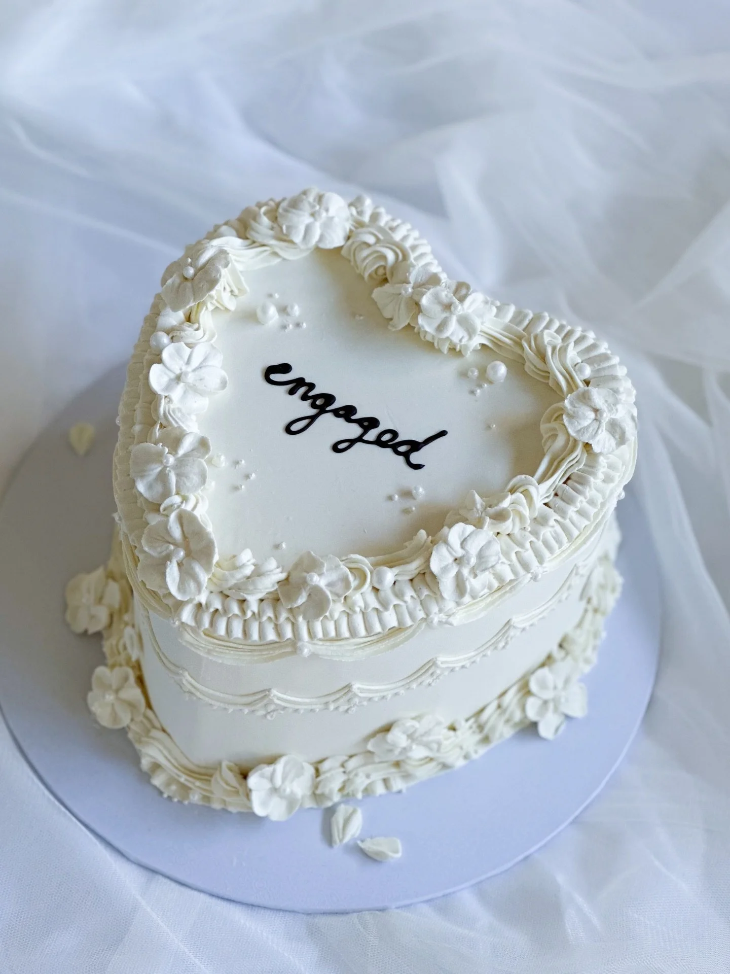 Taylor &amp; Connor 🤍
From September last year! This beauty of an engagement party cake ✨

(and yes&hellip; lots of pretty throwback photos coming from this past half season)

A heart-shaped cake with more elaborate Lambeth piping, finished with han