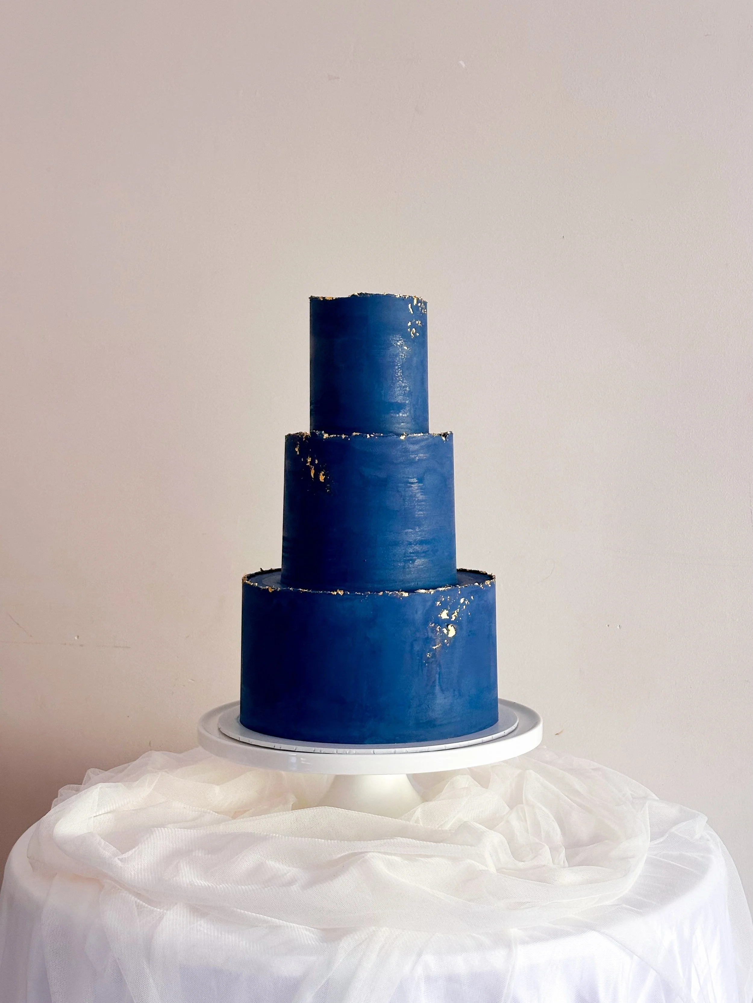 For Kuscha &amp; Anthony 💙✨
A navy blue three-tier cake finished with delicate touches of gold leaf and rough-gilded edging ✨

All three tiers in Espresso Martini flavour, our signature chocolate cake finished with an espresso martini syrup with tou