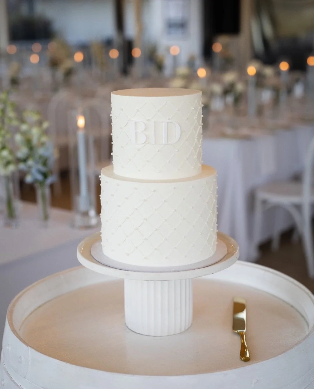 B &amp; D ♡

A little moment of quiet elegance at Aravina Estate, Yallingup. ✨

Two tiers of white beauty, finished with a delicate diagonal stencil texture, pearl details tucked into each corner, and B &amp; D&rsquo;s initials centred on the top tie