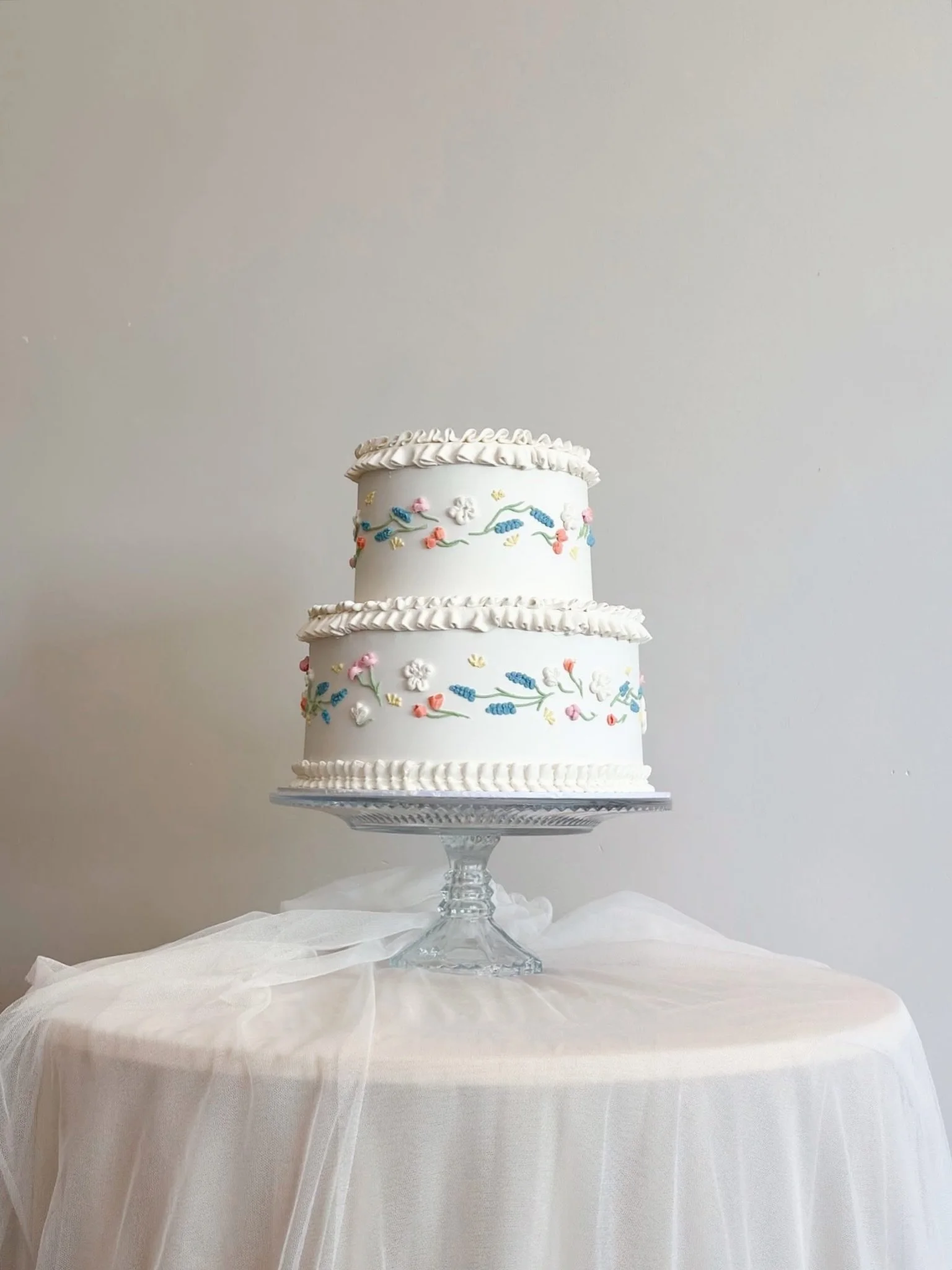 J &amp; N 🤍
A two-tier beauty featuring delicate, hand-made flowers, petals and leaves. With beautiful colours to match her bouquet of soft lilac, blue, ivory and peachy apricot. 

With colour, texture and a whole lot of intricate detailed piping. A