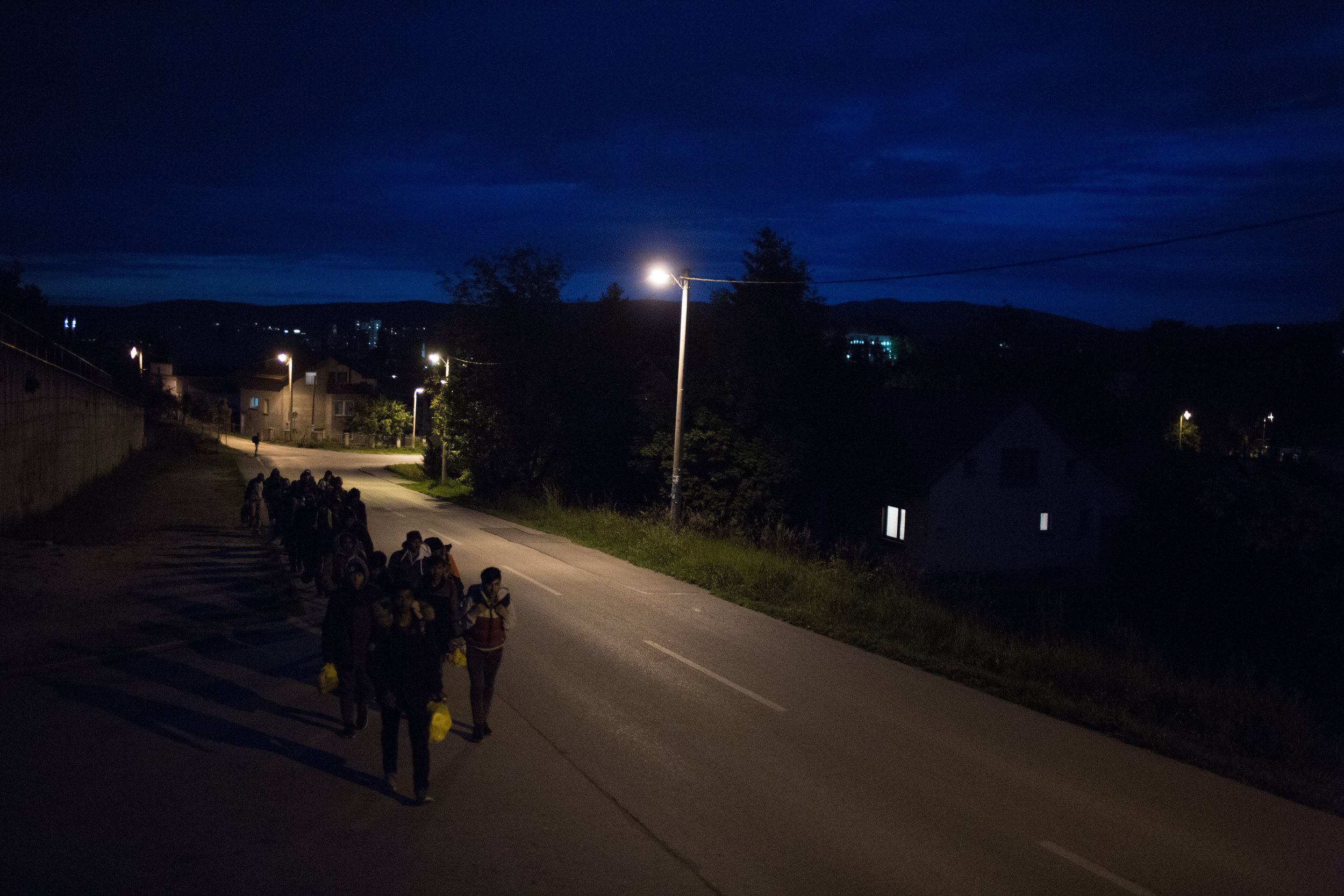 Skupina prebežnikov na nočnem pohodu pri kraju Zavalje v BiH proti Hrvaški. Večinoma si v izogib srečanjem s policisti in prebivalci izberejo manj obljudene ceste in kraje. Noč jim daje zavetje pred nezaželenimi pogledi. 