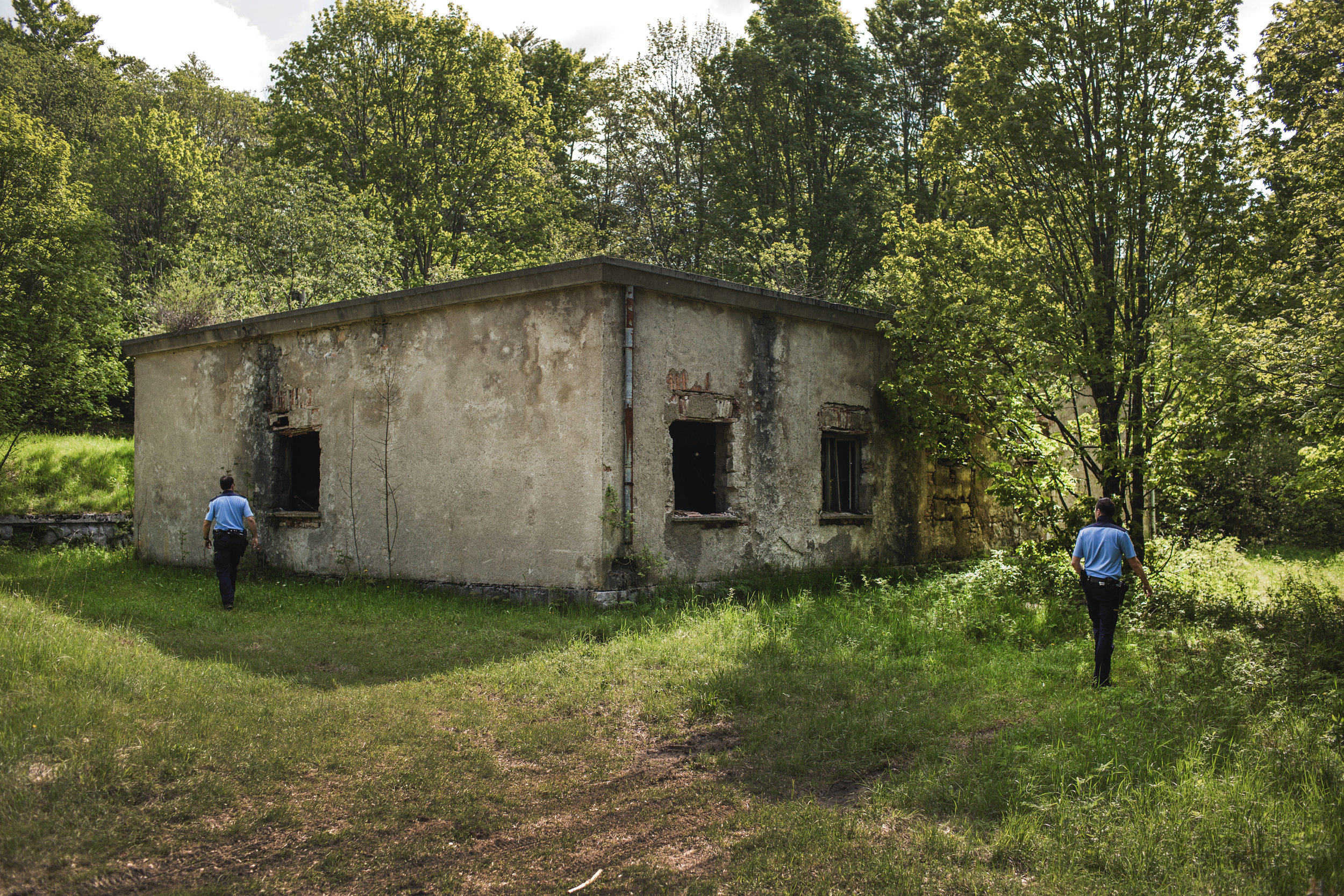  Slovenska policista pregledujeta zapuščeno hišo v gozdu na meji med Slovenijo in Hrvaško, v okolici Ilirke Bistrice, Slovenija 