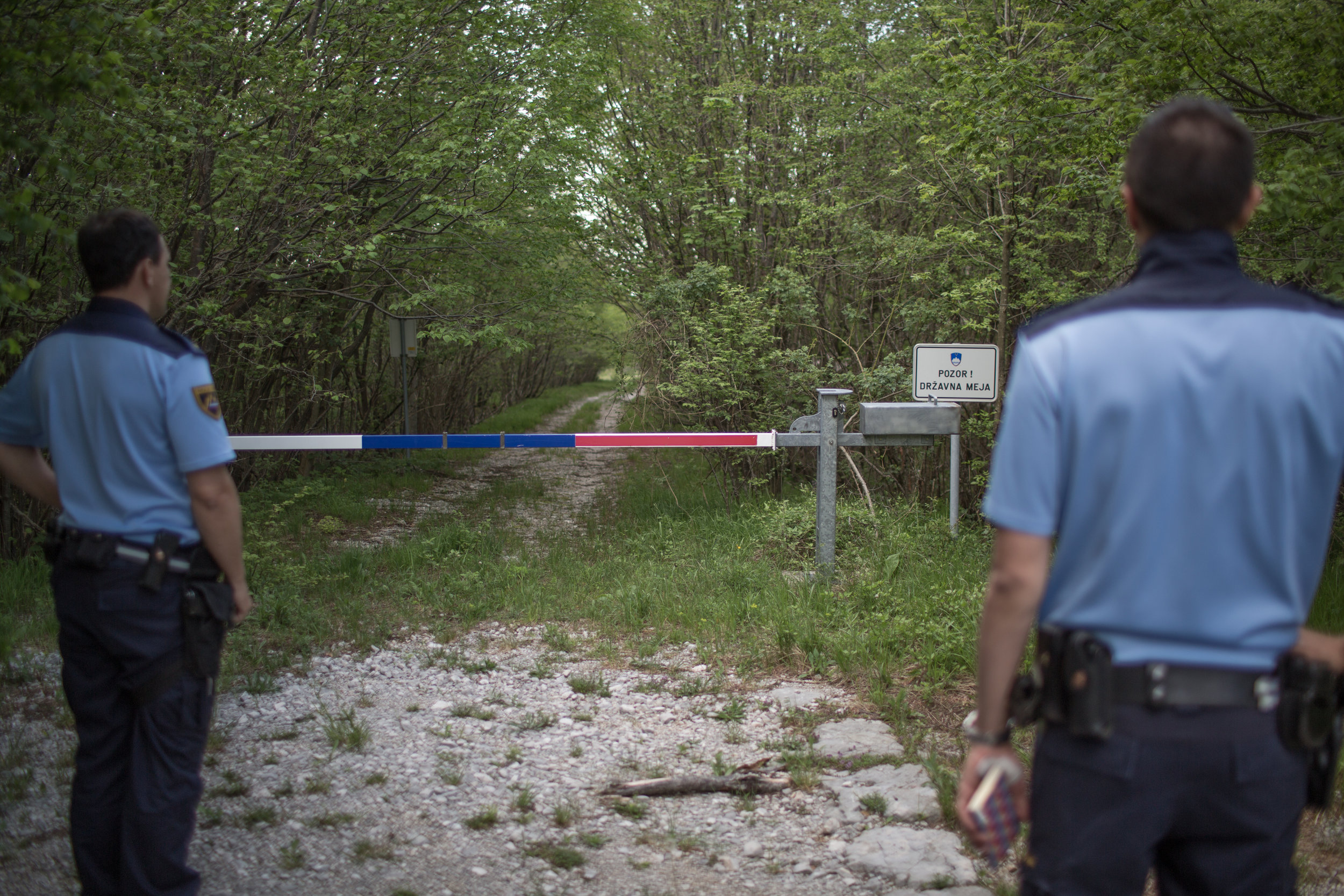  A Slovenian police officer in front of a barrier in a forest at the border between Slovenia and Croatia, in the vicinity of town Ilirska Bistrica, Slovenia. 