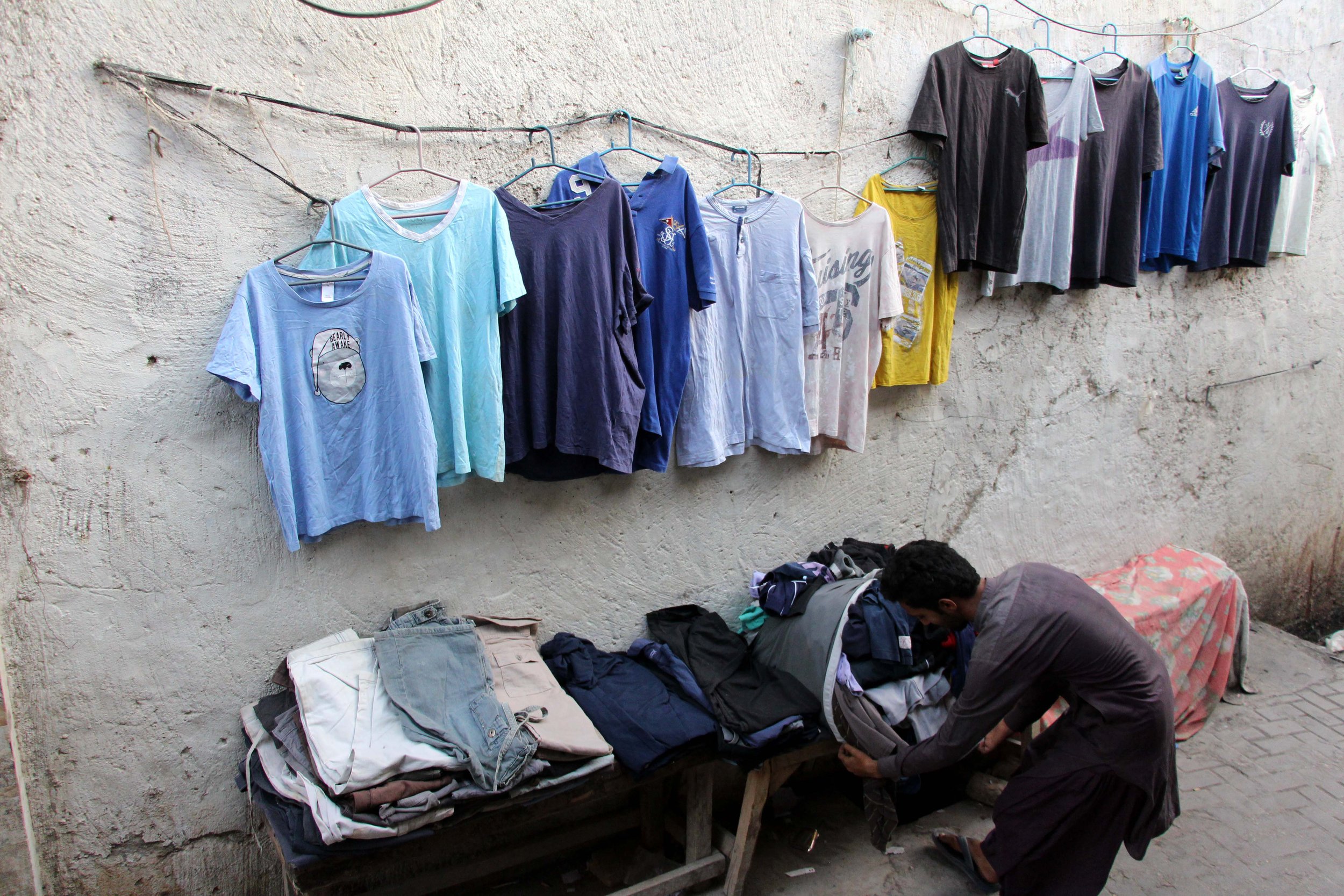  Drugače kot v skladiščih, kjer so obleke naložene v kupih, jih v Larkani, mestu severno od Karačija, razstavijo na stojnicah. Foto: Adil Jawad 