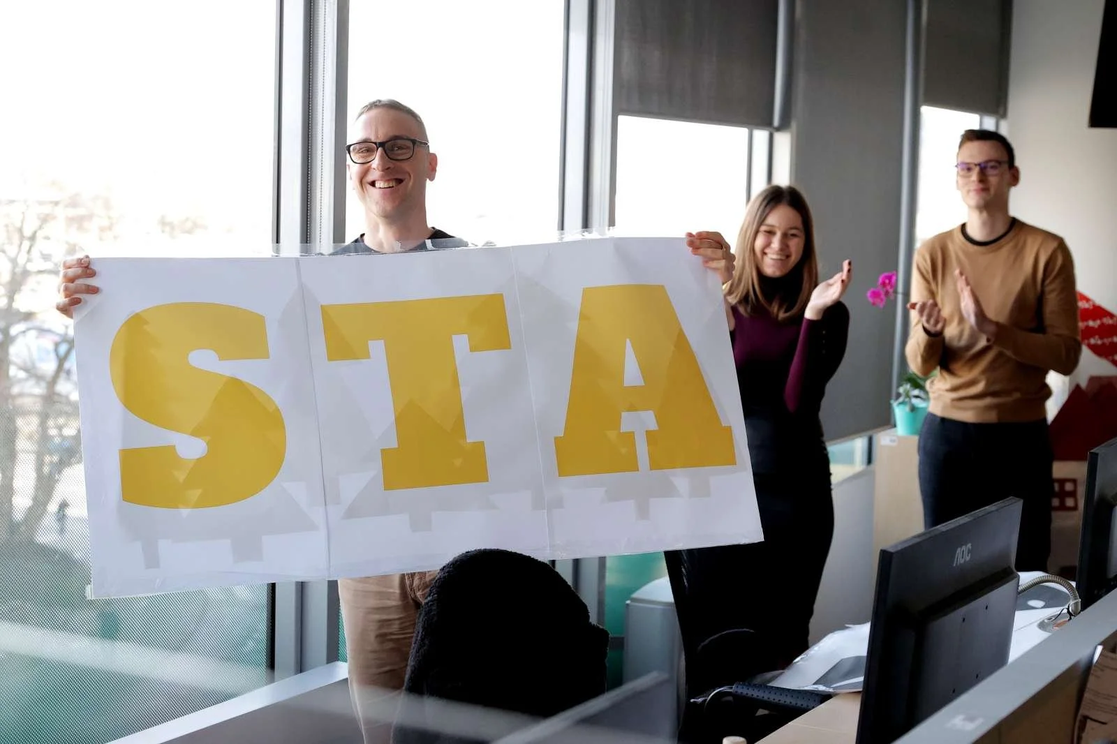  Novinarji so januarja letos ob podpisu pogodbe za financiranje javne službe STA v letu 2023 z oken agencije simbolično umaknili slogan Za obSTAnek, ki je spremljal kampanjo za podporo v času, ko ji je vlada ustavila financiranje. Foto: Daniel Novakovič/STA 