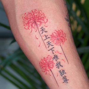 Tattoo of red chrysanthemum flowers with Chinese characters on a person's arm.