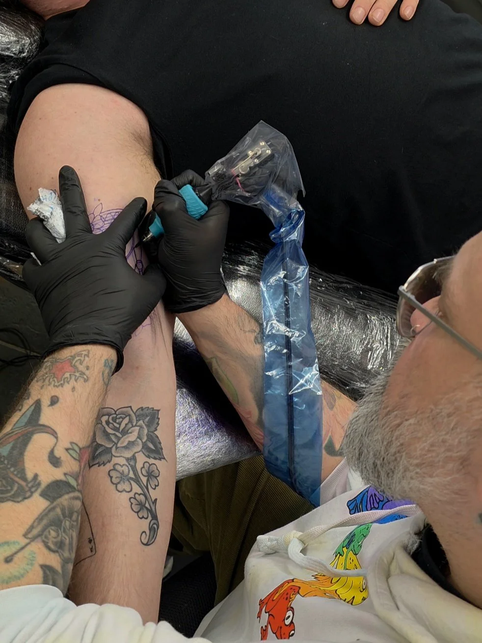 Nick Whybrow is tattooing an hourglass on a clients inner bicep. This was made at The Good Fight tattoo in Camden London