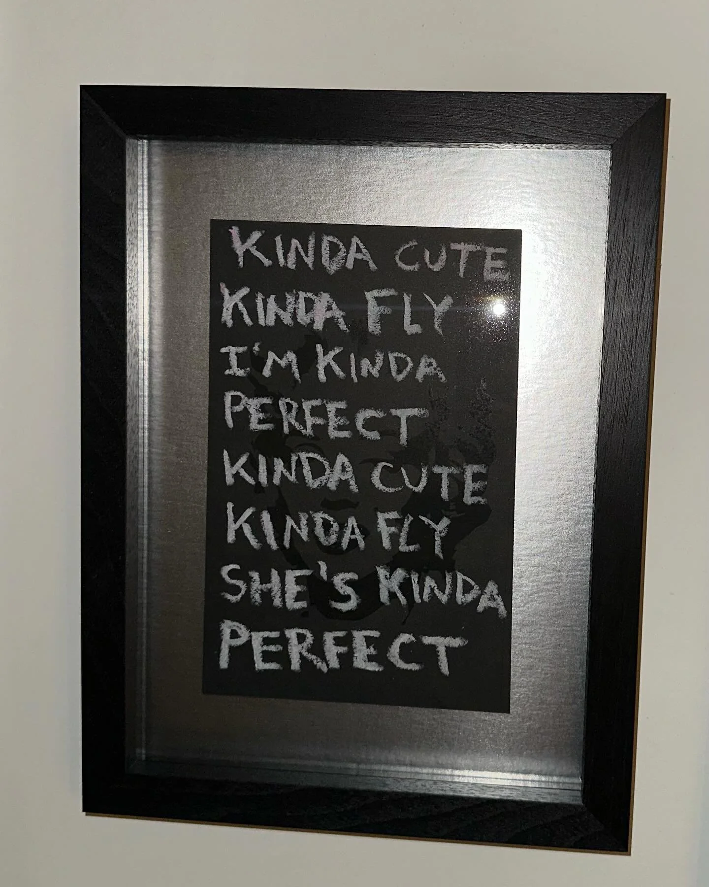 This framed Poppy Baker manuscript turns on inversion: a blacked-out Marilyn Monroe foregrounded by white-coloured hip hop lyrics&mdash;&ldquo;Girls Trip&rdquo; by YT (@tolafolaa).

The metallic silver matting is my favourite moment because I can&rsq