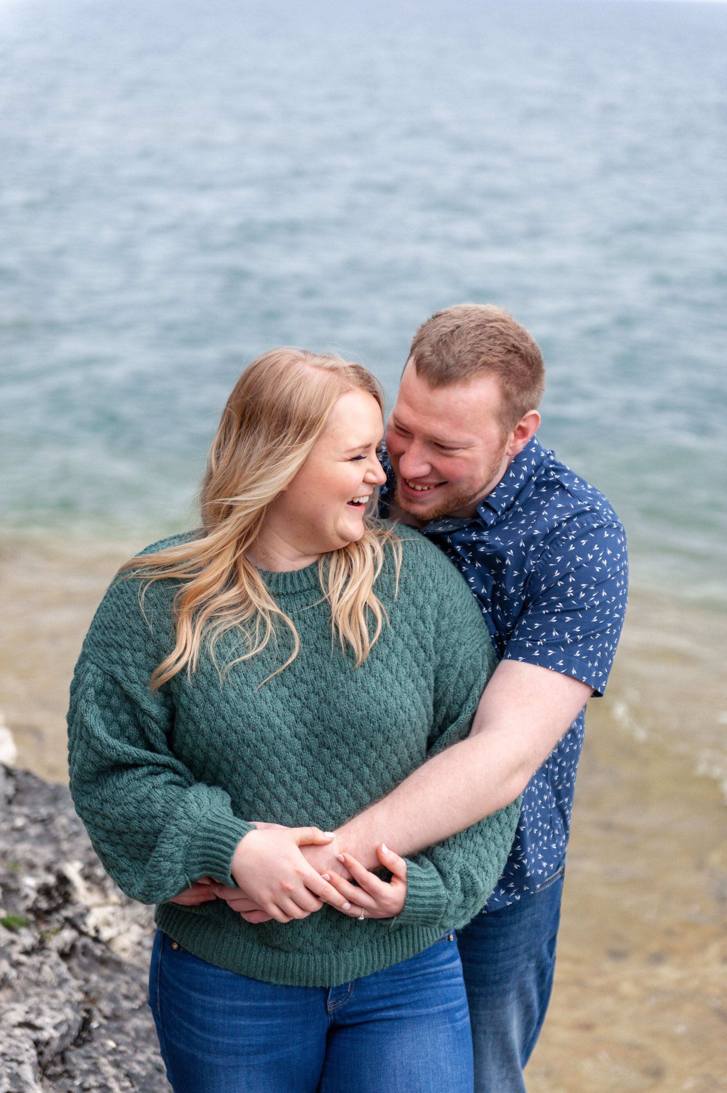 Couple on shore of door county wisconsin engagement session