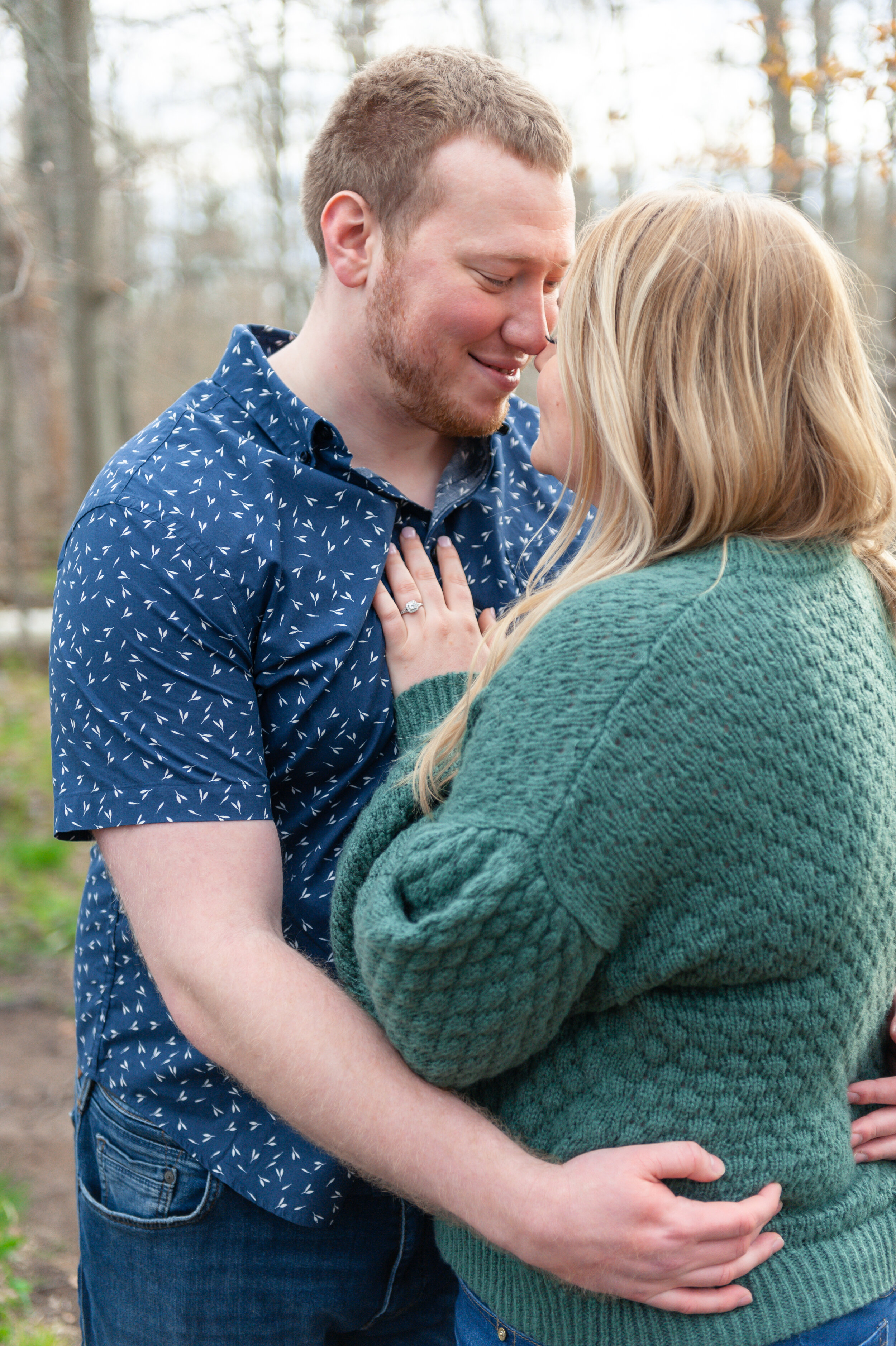 Couple engagement session snugging in the woods