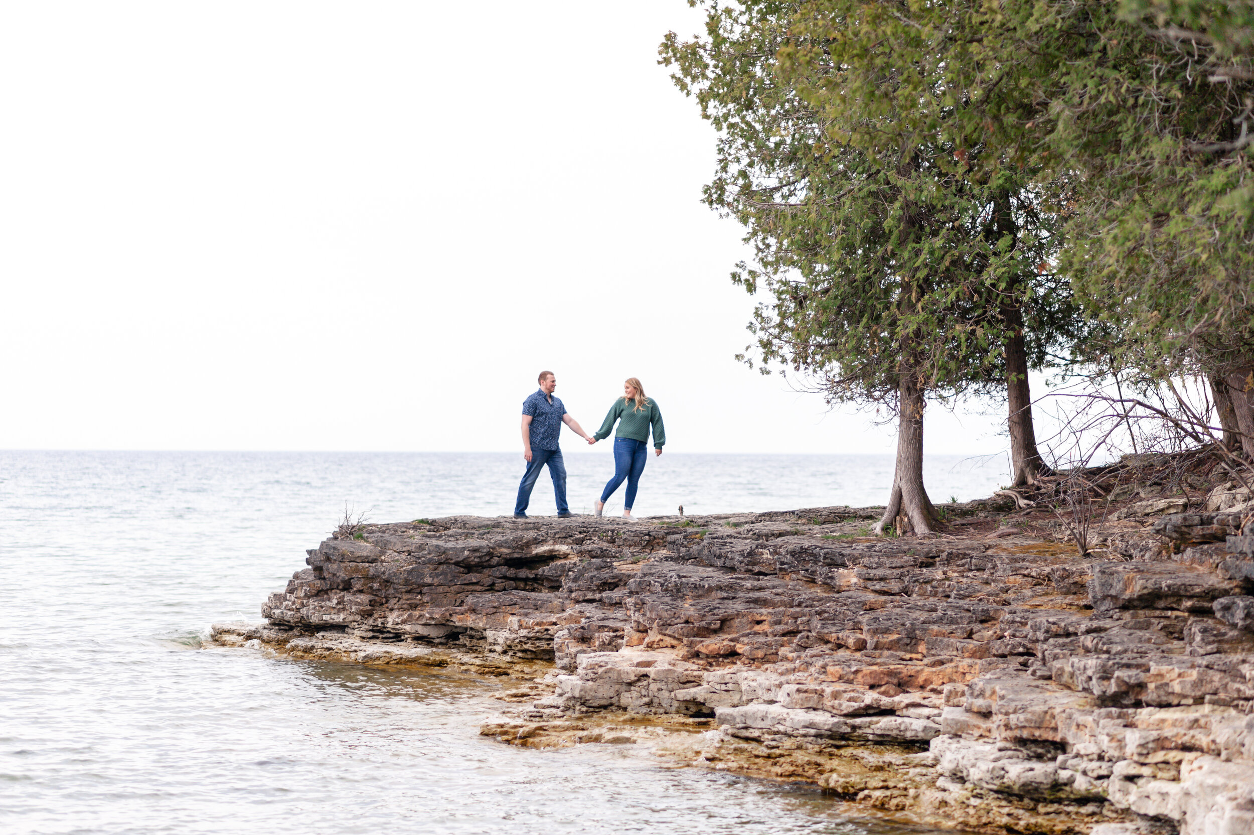 Couple walking on peninsula in door county engagement session