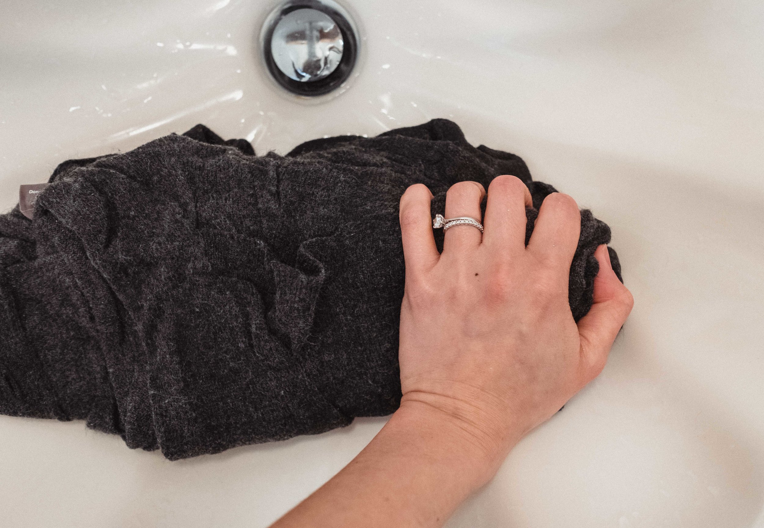 Step 4: after you have drained the water, keeping the sweater in its natural shape, gently squeeze out the water. Again, do NOT wring out the sweater. It does not have to be completely dry at this point and wringing the sweater will cause stretching in the material.