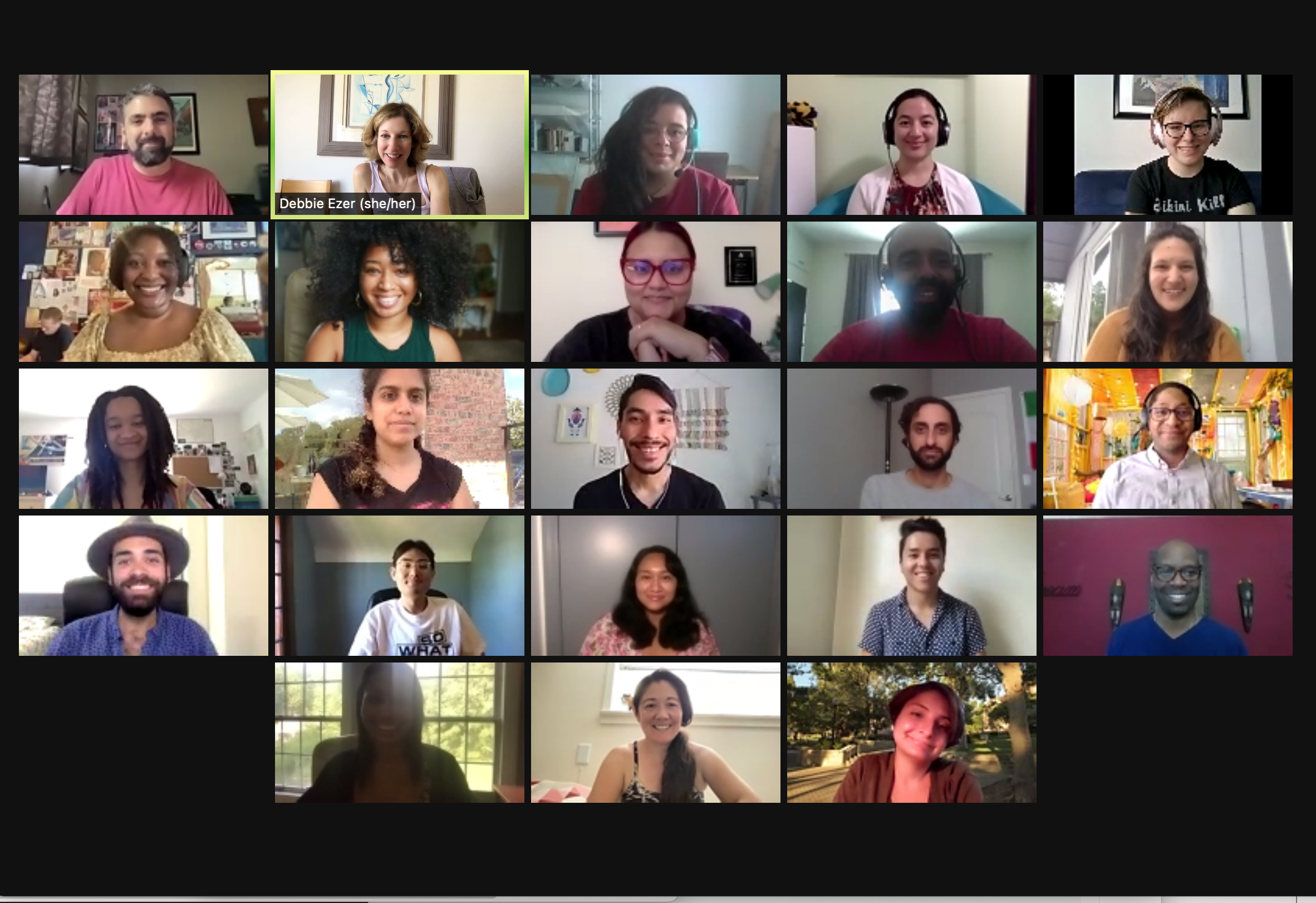 Screenshot of a virtual meeting with 20 diverse participants in individual video frames, some smiling, some with headphones, in various indoor and outdoor backgrounds.