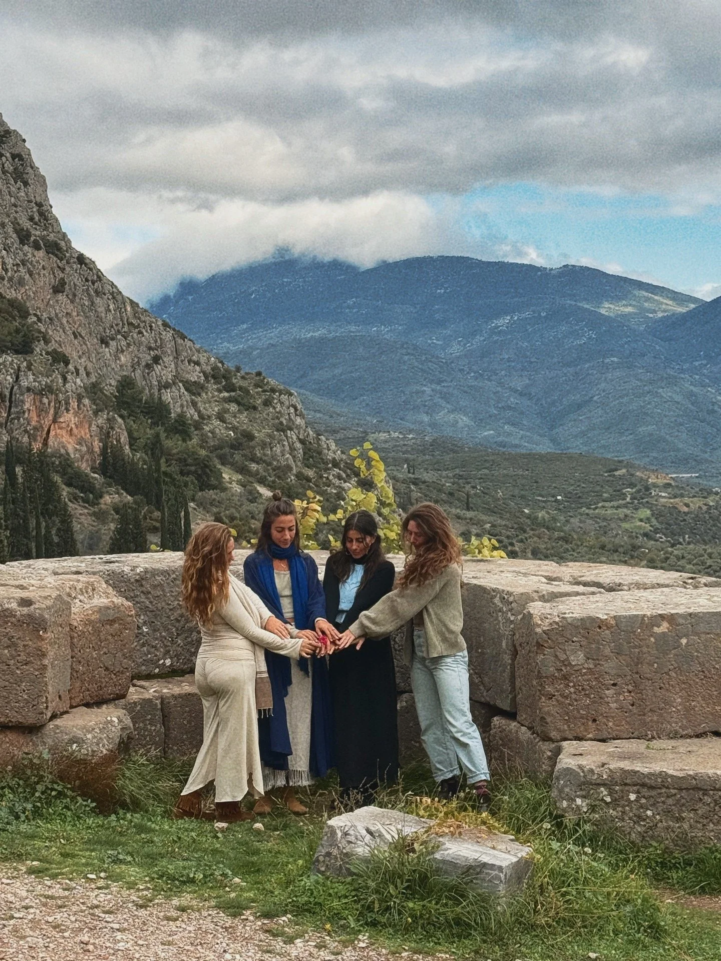  women praying at the temple of the oracle in delphi, greece 