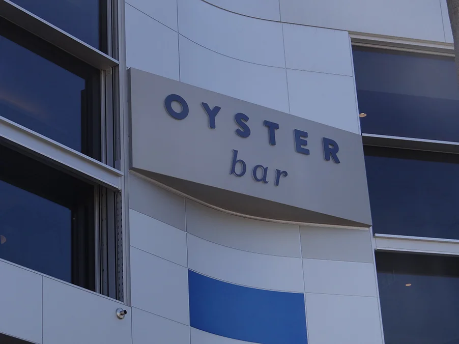 AlFresco Sign Waterjet cut aluminum, fabricated to fit curved building shape, pushed through Acrylic letters with vinyl detail to face. Internally illuminated Letters with LEDS.
