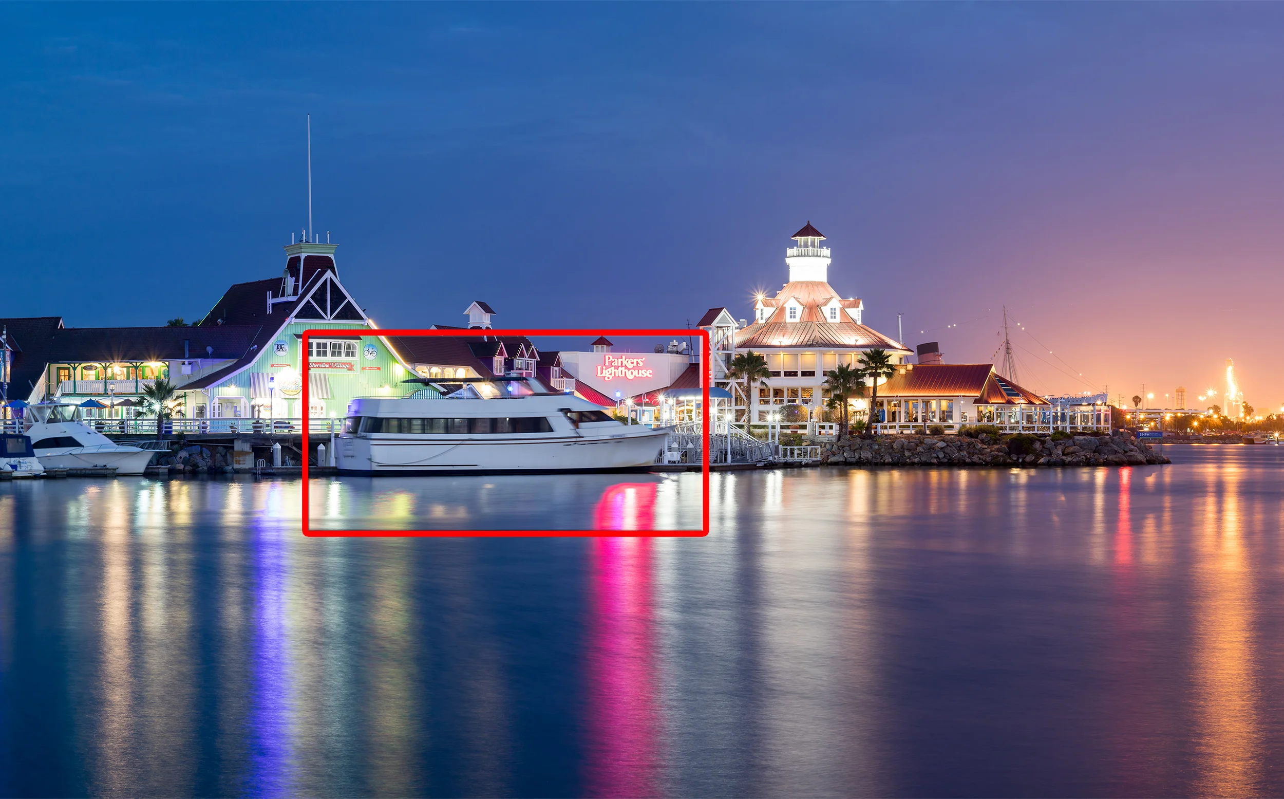 Shoreline village shot on the second night. I wasn't happy with this vantage point. I felt that this large white boat weakens the image. It competes with the illuminated buildings as a subject. The significant motion blur from bobbing up and down in the water is also distracting. However, I could not find a composition I liked from this location that did not include the boat. 