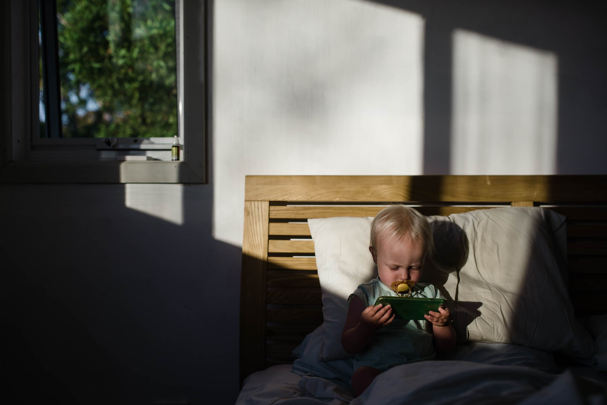 learning_photography_toddler_watching_phone_in_bed-1.jpg