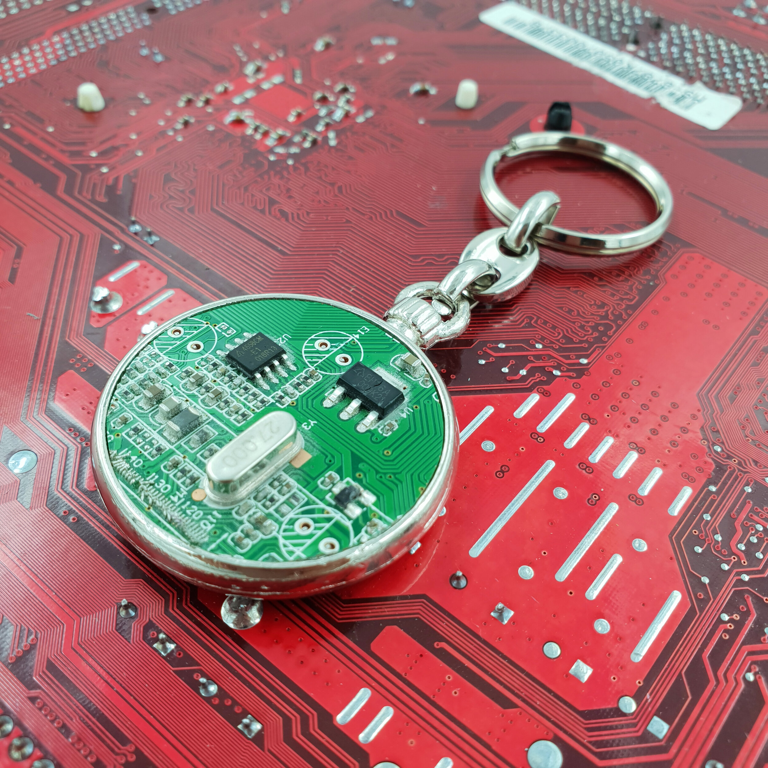 Green keyring on red circuit board 