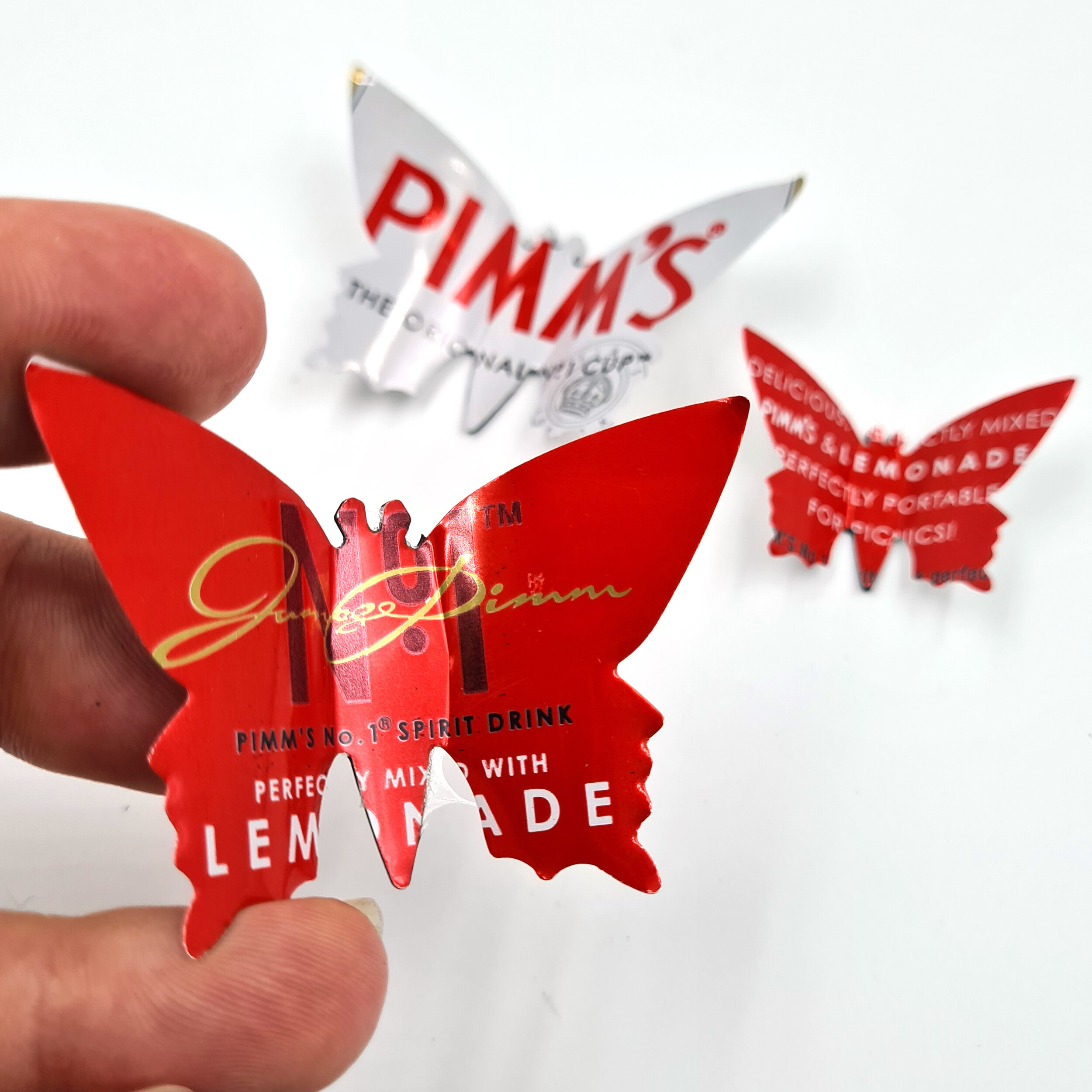 Pimm's red and white eco Butterfly Can Magnets holding 