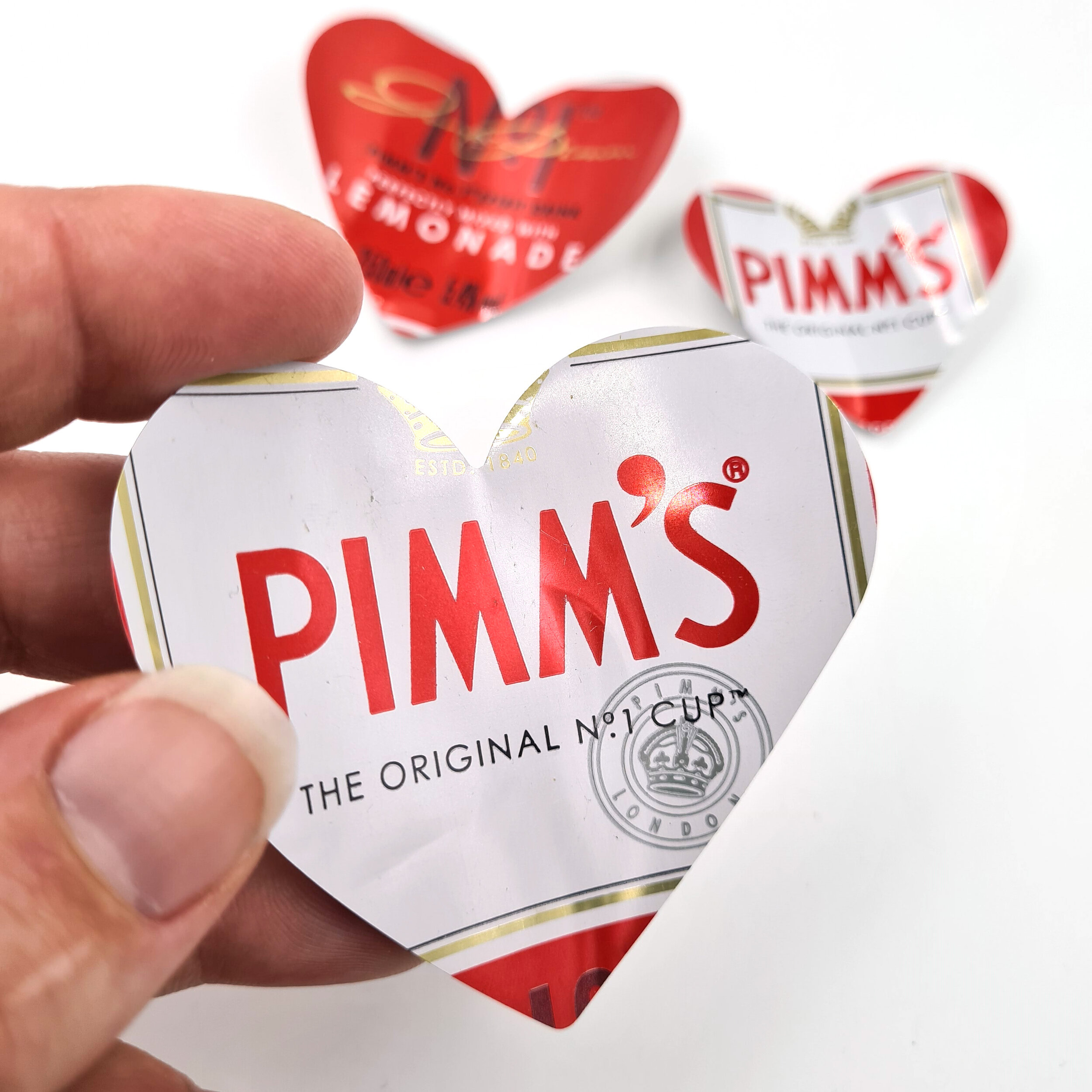 Red and white sustainable Pimm's Heart Can Magnets holding