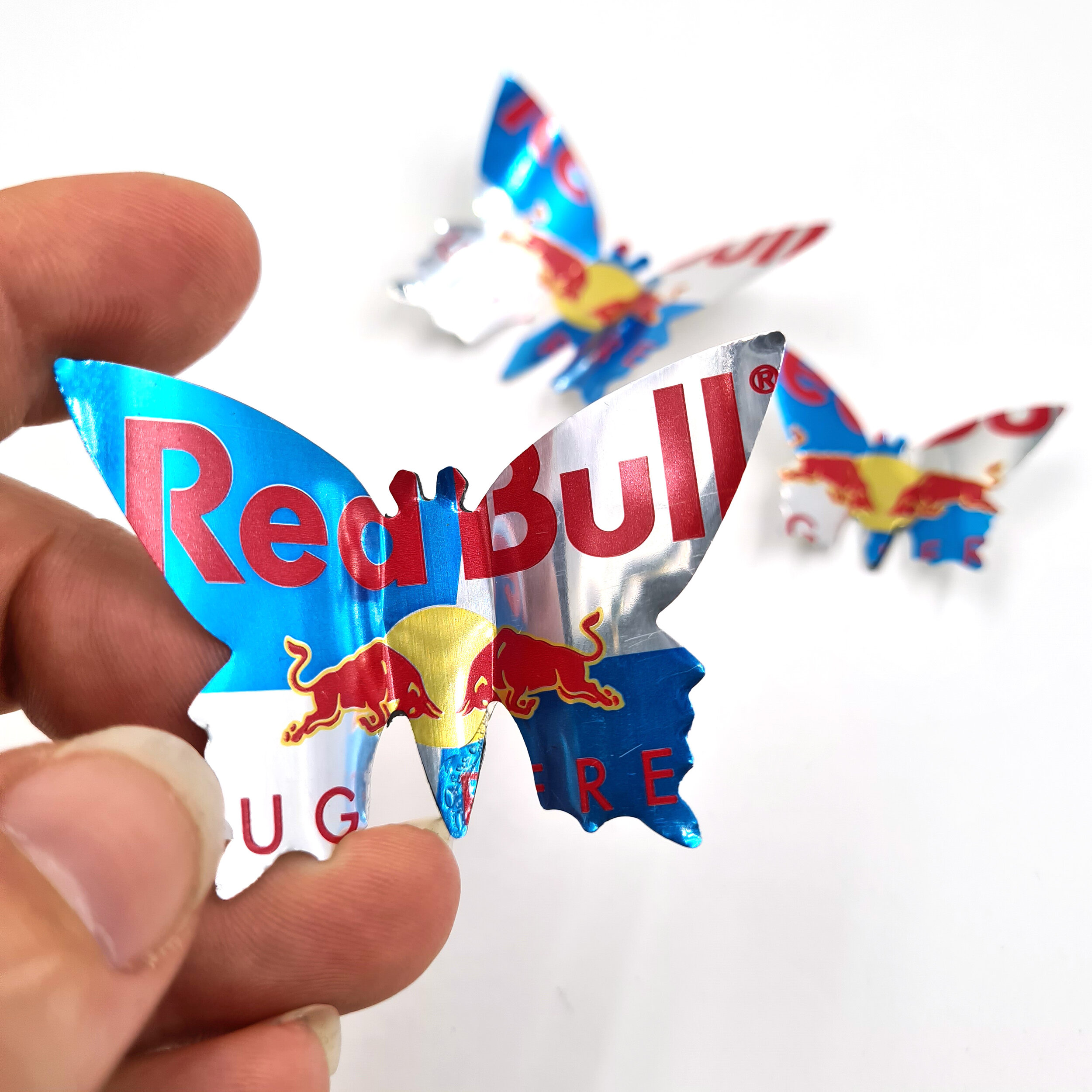 Red Creative sustainable Red Bull Sugar Free Butterfly Can Magnets holding