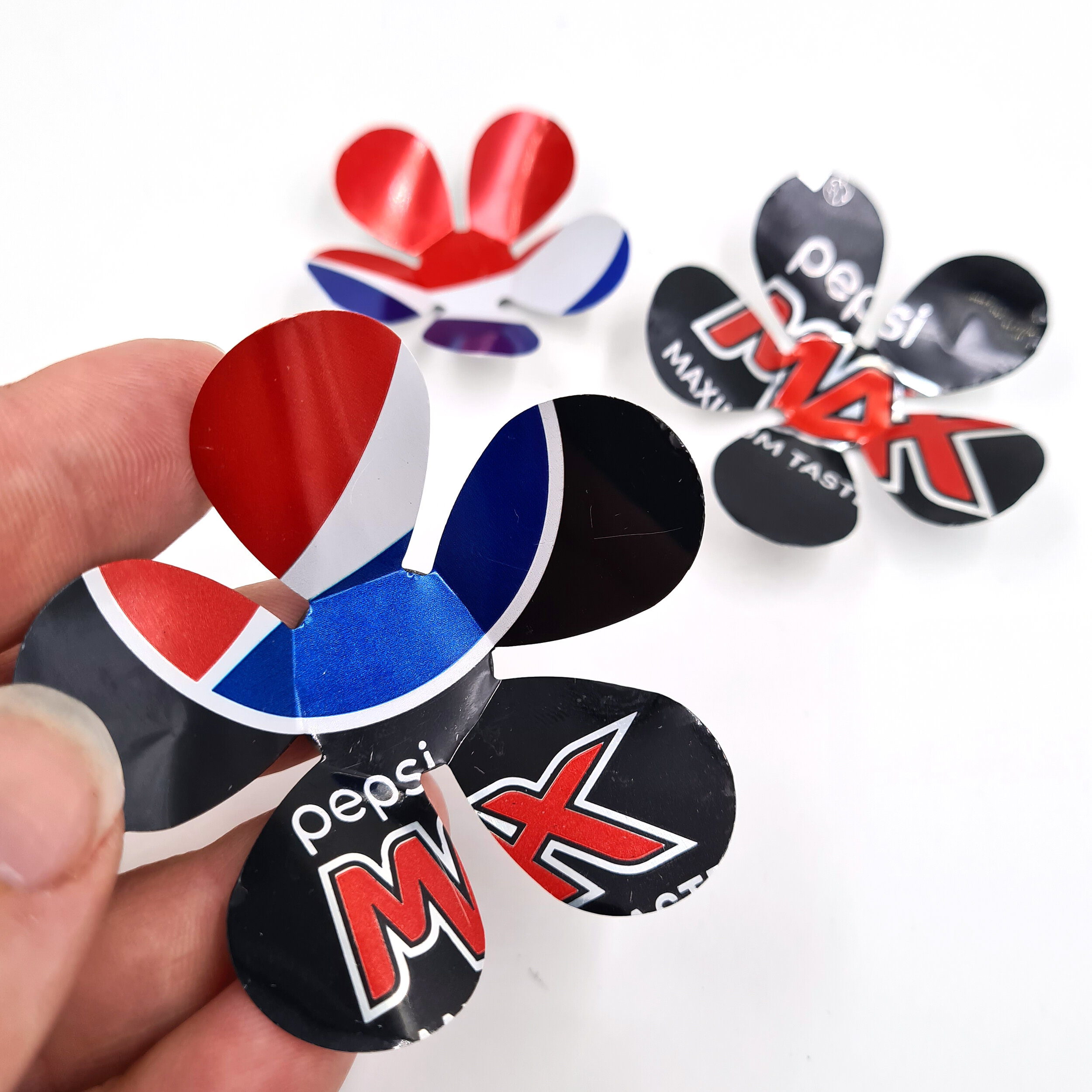 Red and blue creative eco design Pepsi Max Can Flower Magnets holding 