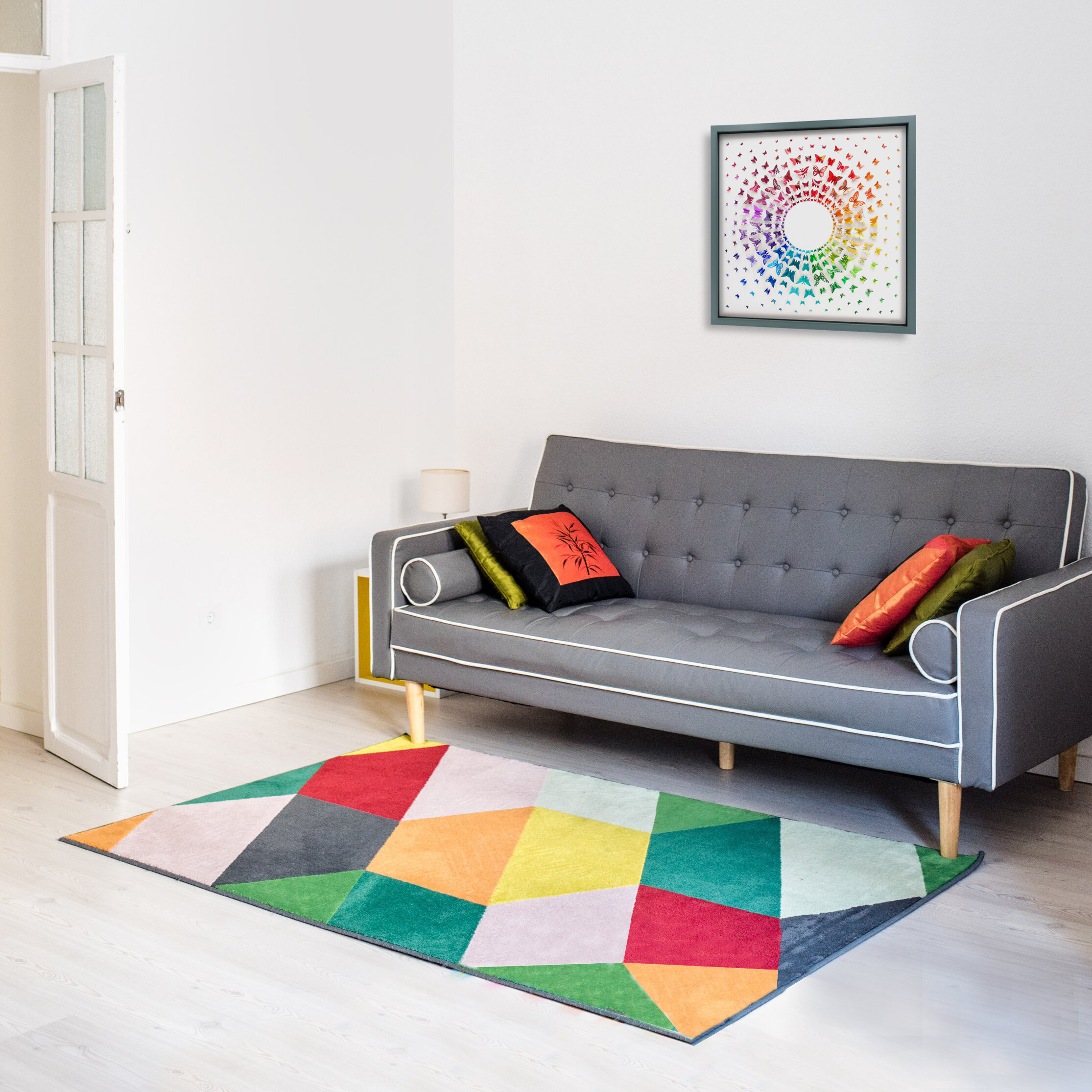 Rainbow butterflies artwork arranged in a circle hung on a wall with a sofa and rug