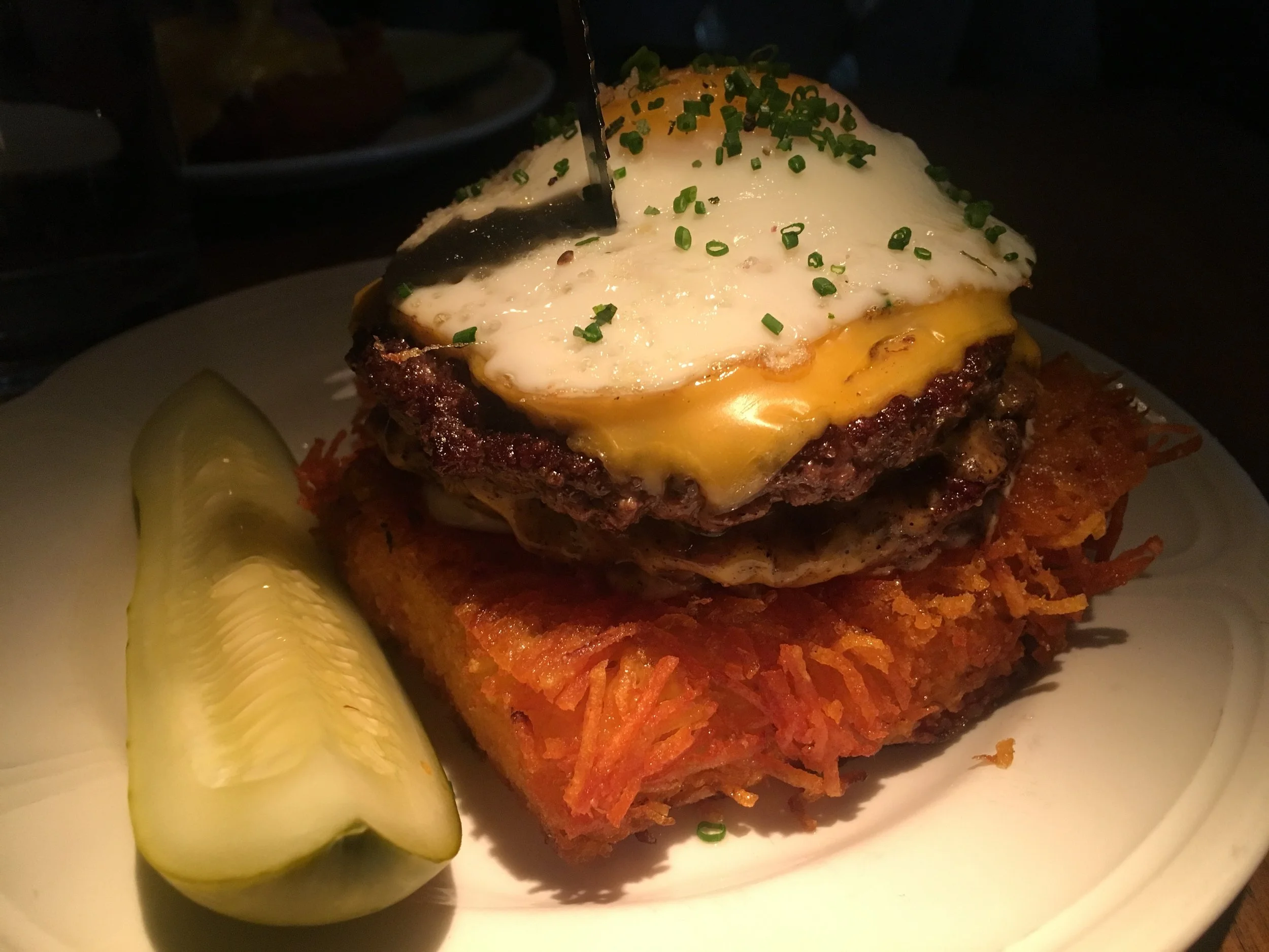 open faced single cheeseburger on crispy hash, with an egg