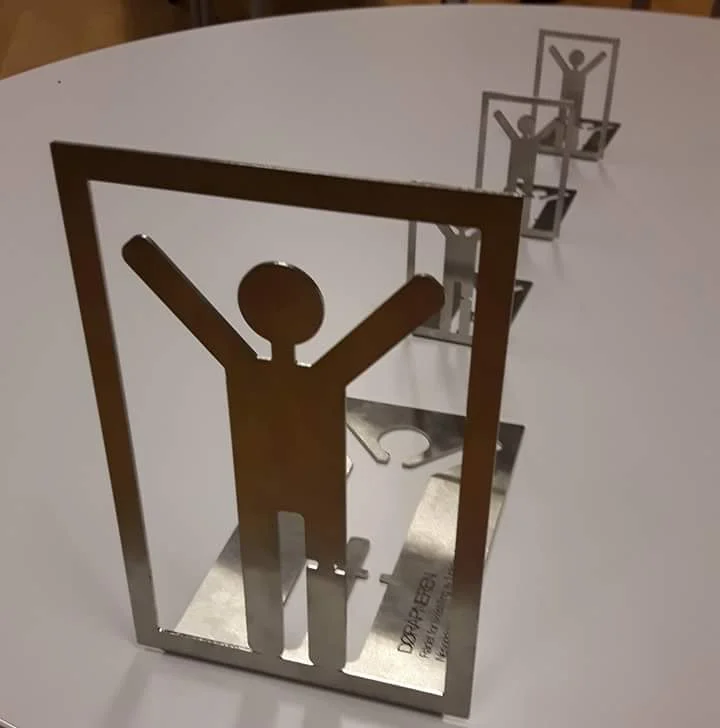 Døråpneren er en vandrepokal utarbeidet på oppdrag for Rådet for likestilling av funksjonshemmede ved Nesodden kommune.