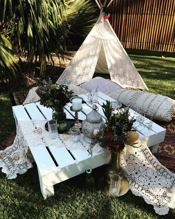 White pallet in center of blankets/seating w/cookies, coffee and milk.