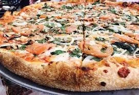 Close-up of a pepperoni and vegetable pizza with a golden crust.