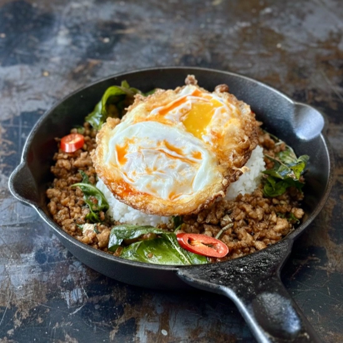 Sizzling KraPow Volcano 🌋🔥
Spicy. Meaty. Exploding with flavor.
Finished with extra cozy, droowy fried egg yolks. 🍳✨