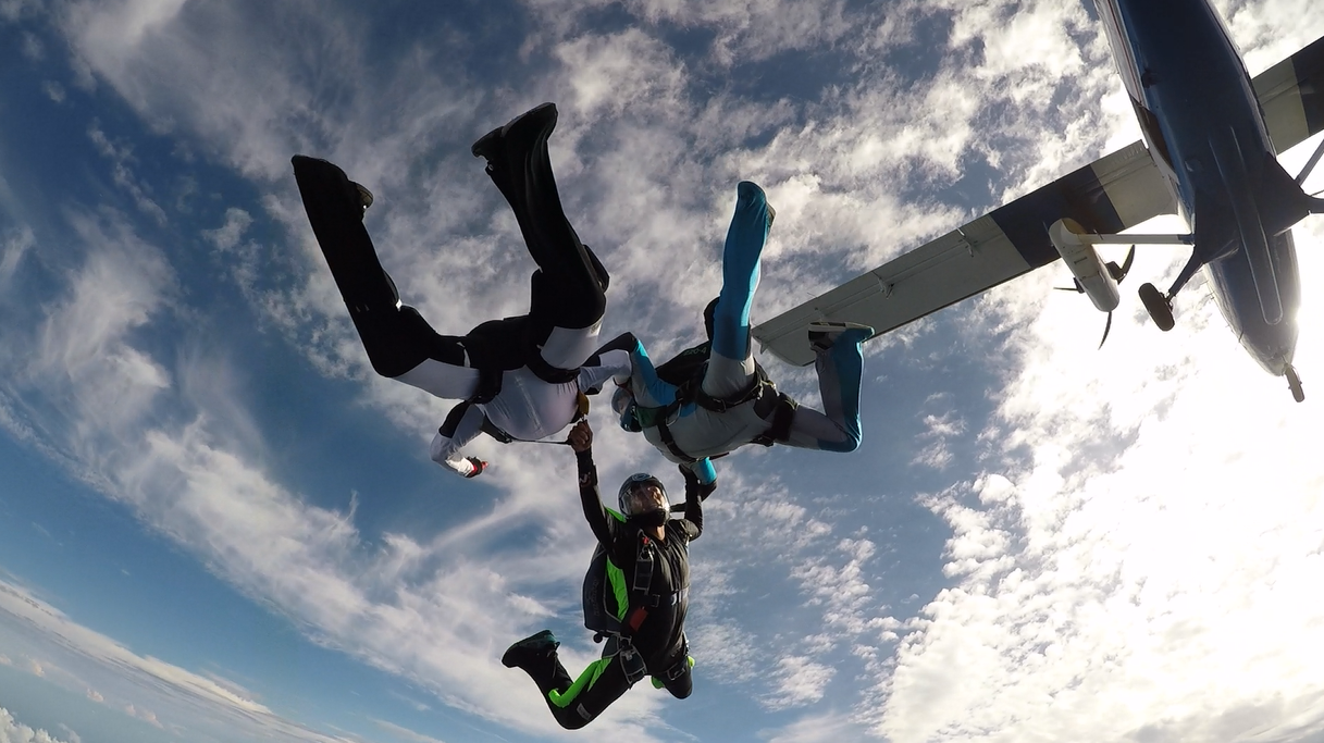 Eli (bottom figure) exits a twin otter at 13,500 ft AGL along with two other skydivers. Photo courtesy of Danielle Williams.