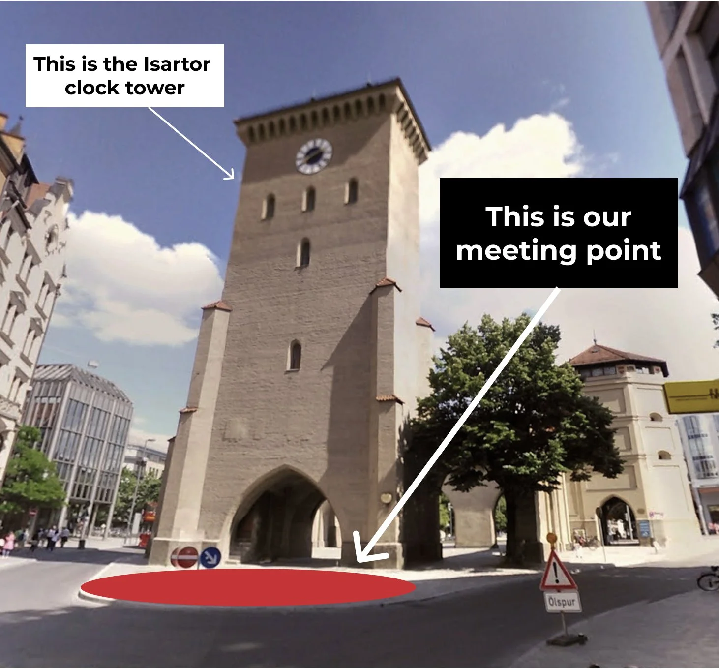 A historic clock tower with annotations indicating it's the Isartor clock tower, with a meeting point marked on the ground in front of the tower, under a partly cloudy sky in an urban setting.