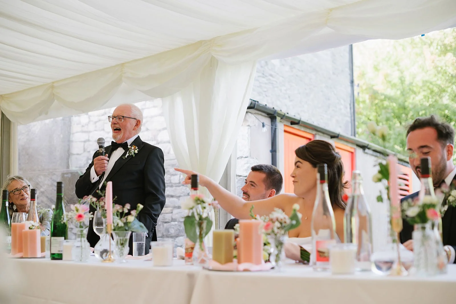 Bride and groom laughing during wedding speeches