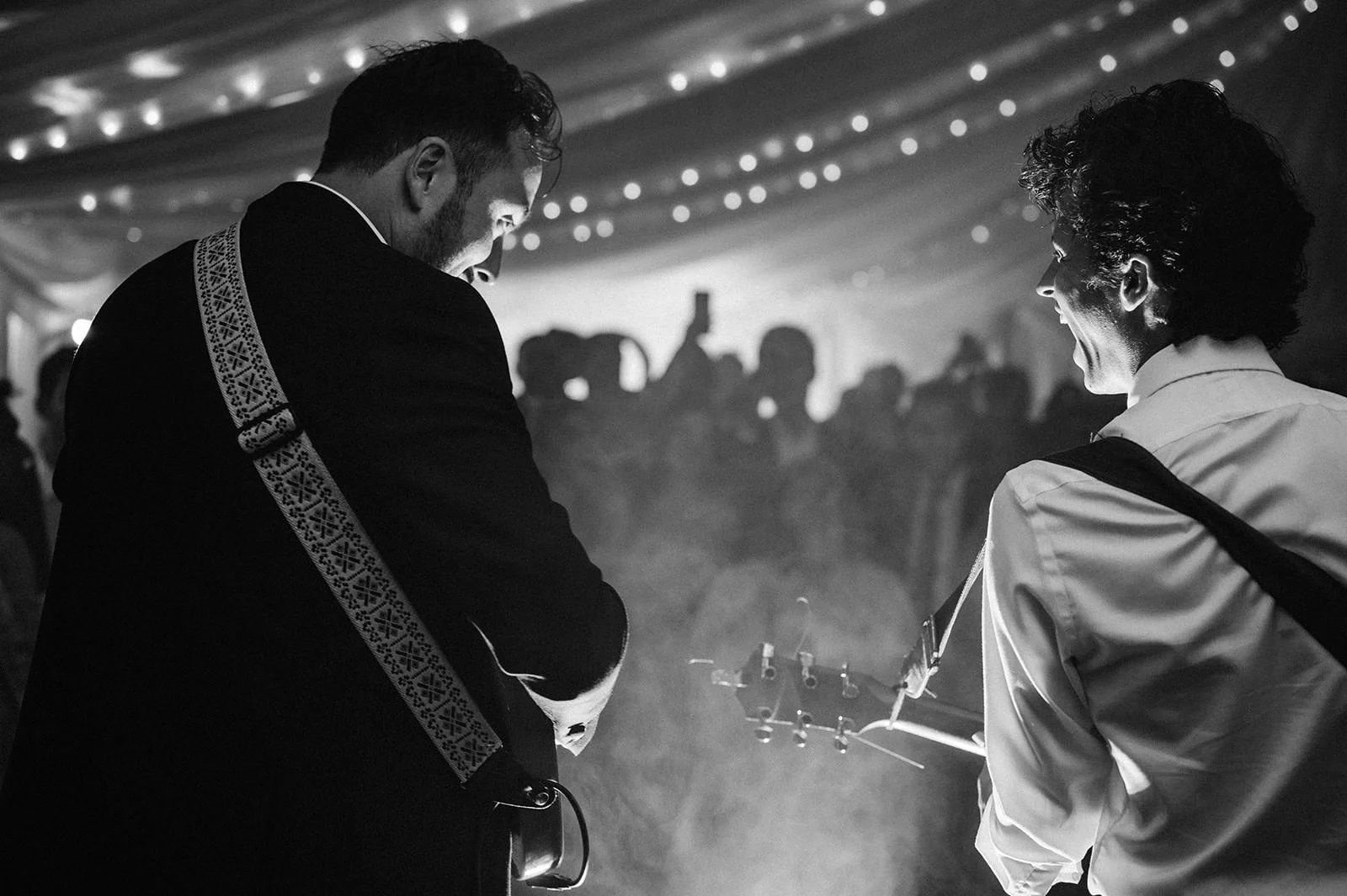 Groom playing guitar during wedding reception